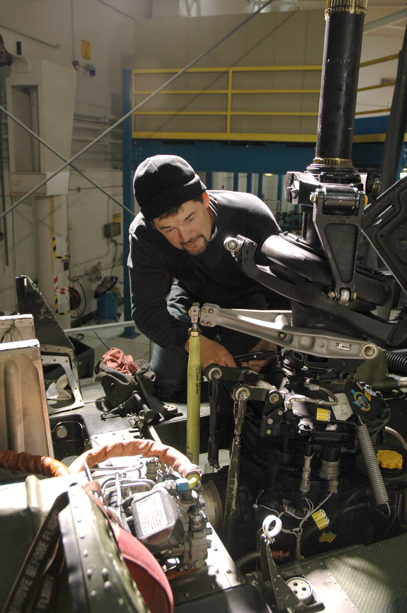 Mike Coleman, civilian maintenance contractor at the 40th Helicopter Squadron, re-attaches a swash plate assembly back to the transmission on a UH-1N Huey helicopter at Malmstrom Air Force Base, Mont., Oct. 31. Mr. Coleman is one of 16 civilian contractors who work flightline and phase dock maintenance here. (U.S. Air Force photo/Senior Airman Eydie Sakura)