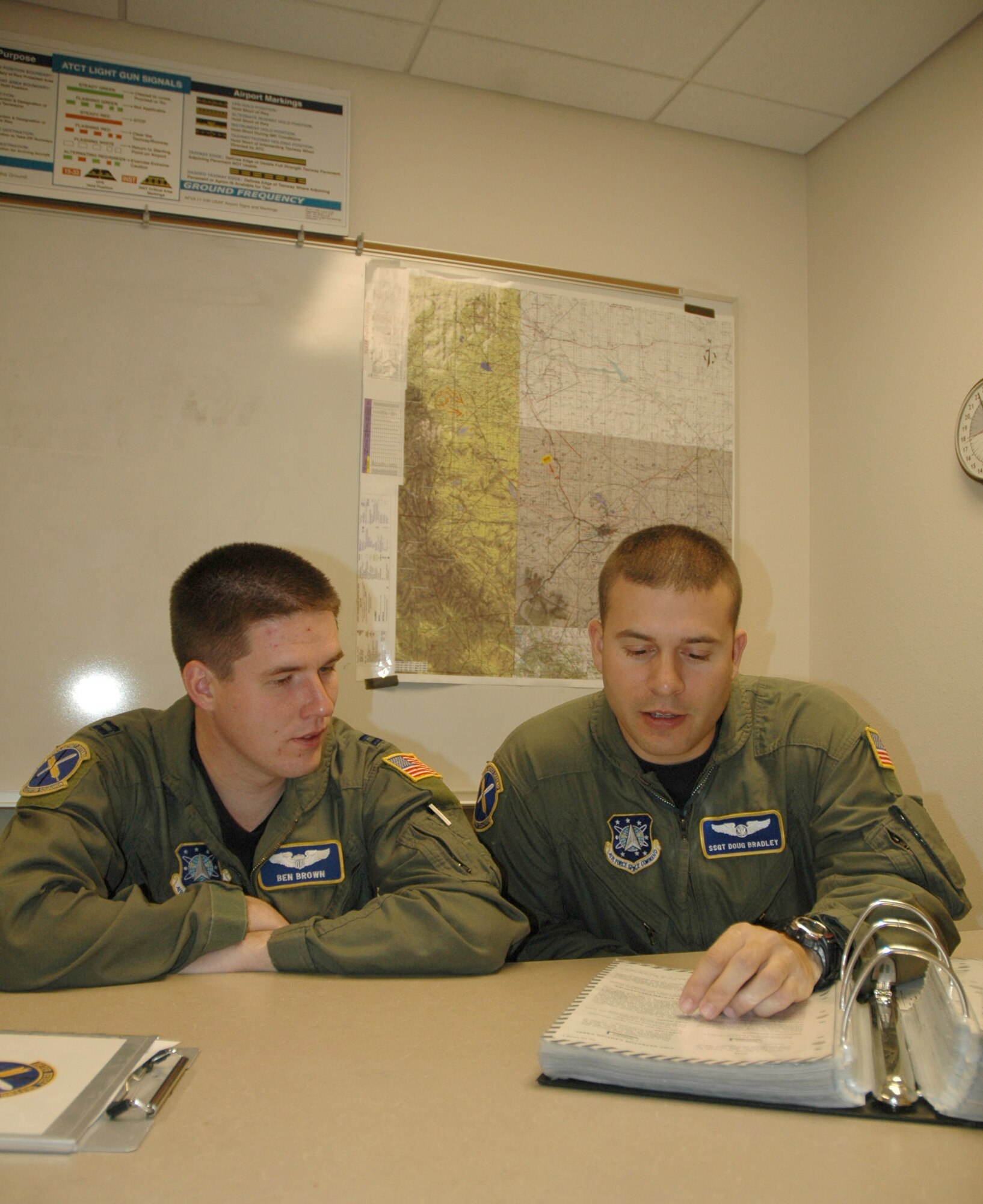 Capt. Ben Brown, 40th Helicopter Squadron pilot, listens to 40th HS flight engineer, Staff Sgt. Doug Bradley's pre-flight brief at Malmstrom Air Force Base, Mont., Oct. 31, prior to their morning sortie in a UH-1N Huey helicopter. The UH-1N is a light-lift utility helicopter used to support Air Force Space Command missile wings and groups. (U.S. Air Force photo/Senior Airman Eydie Sakura)