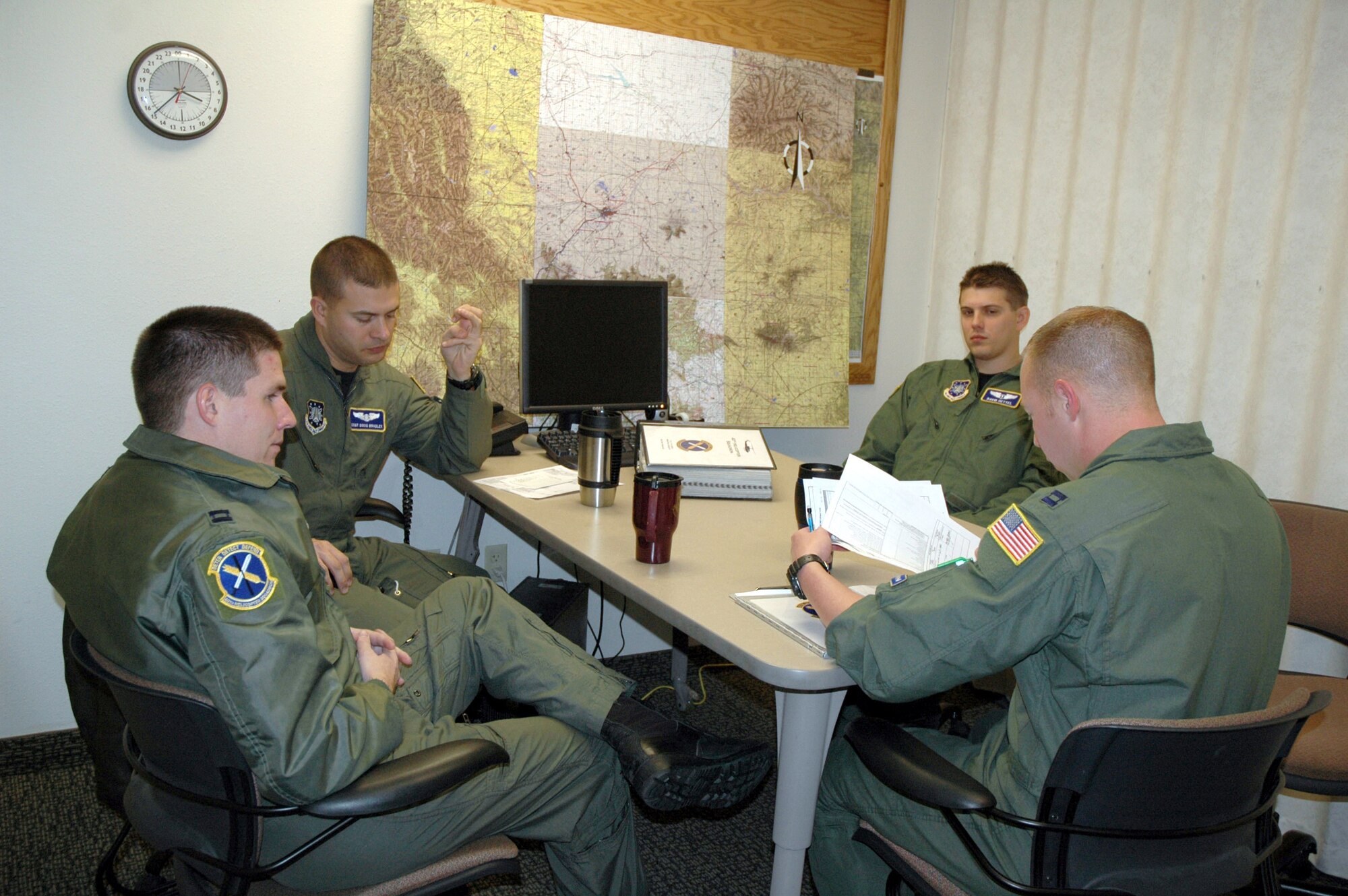 Capt. Ben Brown, 40th Helicopter Squadron pilot; Staff Sgt. Doug Bradley, 40th HS flight engineer; and Capt. David Oettel, 341st Medical Operations Squadron flight doctor, listen to Capt. Daran Gaus, 40th HS pilot, during a pre-flight briefing Oct. 31 at Malmstrom Air Force Base, Mont. The crew was preparing for a flight in a UH-1N Huey, a light-lift utility helicopter used to support Air Force Space Command missile wings and groups. (U.S. Air Force photo/Senior Airman Eydie Sakura)
