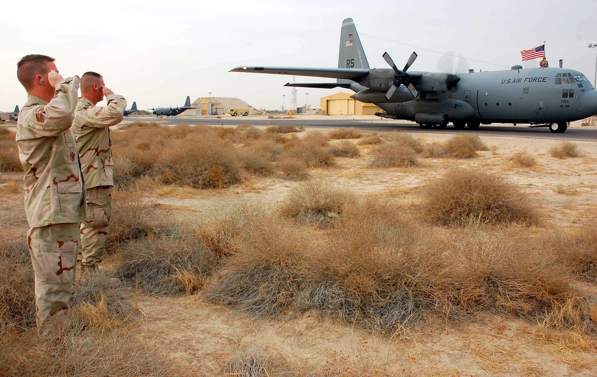 Airmen from the 386th Air Expeditionary Wing salute a C-130 Hercules, tail number 63-7865, Nov. 13 in Southwest Asia. The aircraft from Ramstein Air Base, Germany, had just flown its last combat mission and will be flown to Davis-Monthan Air Force Base, Ariz., where it will be laid to rest at the "boneyard." (U.S. Air Force photo/Staff Sgt. Tia Schroeder) 

