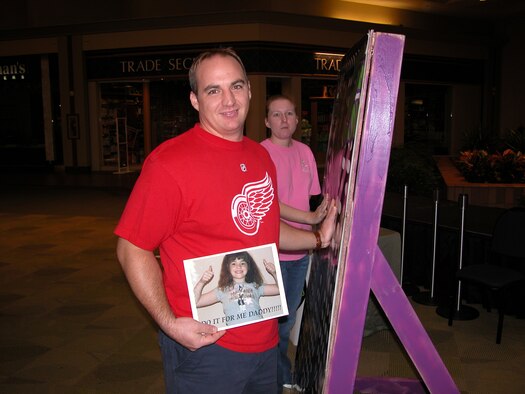 Joe Densmore, a technical sergeant and 917th jet engine shop employee, holds firm to a Hannah Montana promtional poster at a local mall Thursday, Nov. 15, in hopes of winning bckstage tickets for his daughter. The concert is scheduled for tonight at a local concert arena. Turns out, Joe held out long enough and split the four passes up for grabs with a lady from Marshall, Texas. Congratulations! You daughter thanks you! (U.S. Air Force photo/Master Sgt. Al Horn)