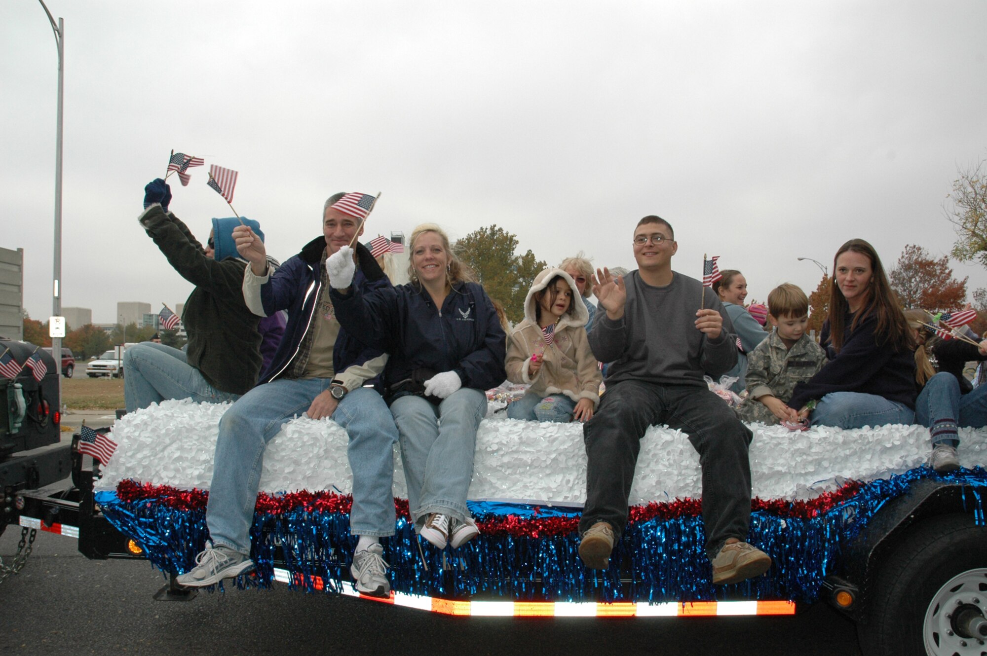 MCCONNELL AIR FORCE BASE, Kan. – Family members of deployed McConnell Airmen wave flags at parade observers at the Wichita Veteran’s Day Parade Nov. 11 in honor of military veterans and servicemembers. (photo by Tech. Sgt. Genevieve Morris)