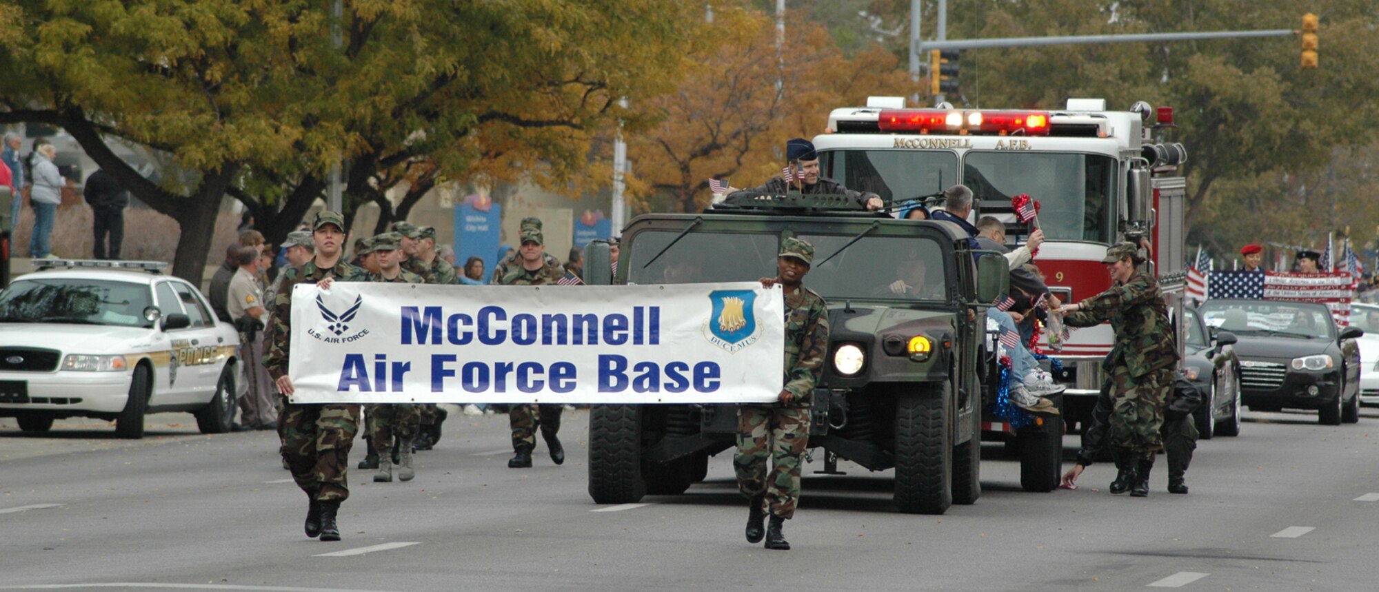 MCCONNELL AIR FORCE BASE, Kan. – Members from McConnell strolls down a street in Wichita during the 2007 Veteran’s Day parade, Nov. 11. Col. John Zazworsky, 22nd Air Refueling Wing acting commander, and families of deployed McConnell members wave at parade spectators. (photo by Tech. Sgt. Genevieve Morris)