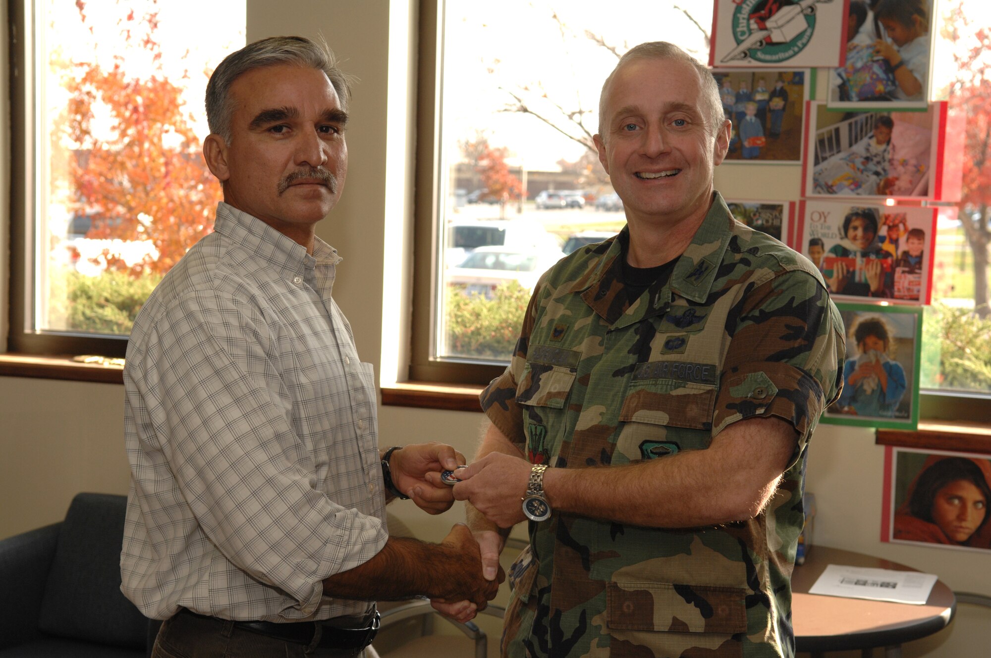 WHITEMAN AIR FORCE BASE, Mo. -- Col. Garrett Harencak, 509th Bomb Wing commander, presents one of his commander’s coins to Juan Gonzales, Boeing B-2 mission planner Nov. 13. Mr. Gonzales received the coin for building the colonel’s first B-2 flight plan and for being a part of the combat capability provided to the wing’s mission by the 509th Operations Support Squadron. (U.S. Air Force photo/Airman 1st Class Stephanie Clark)
