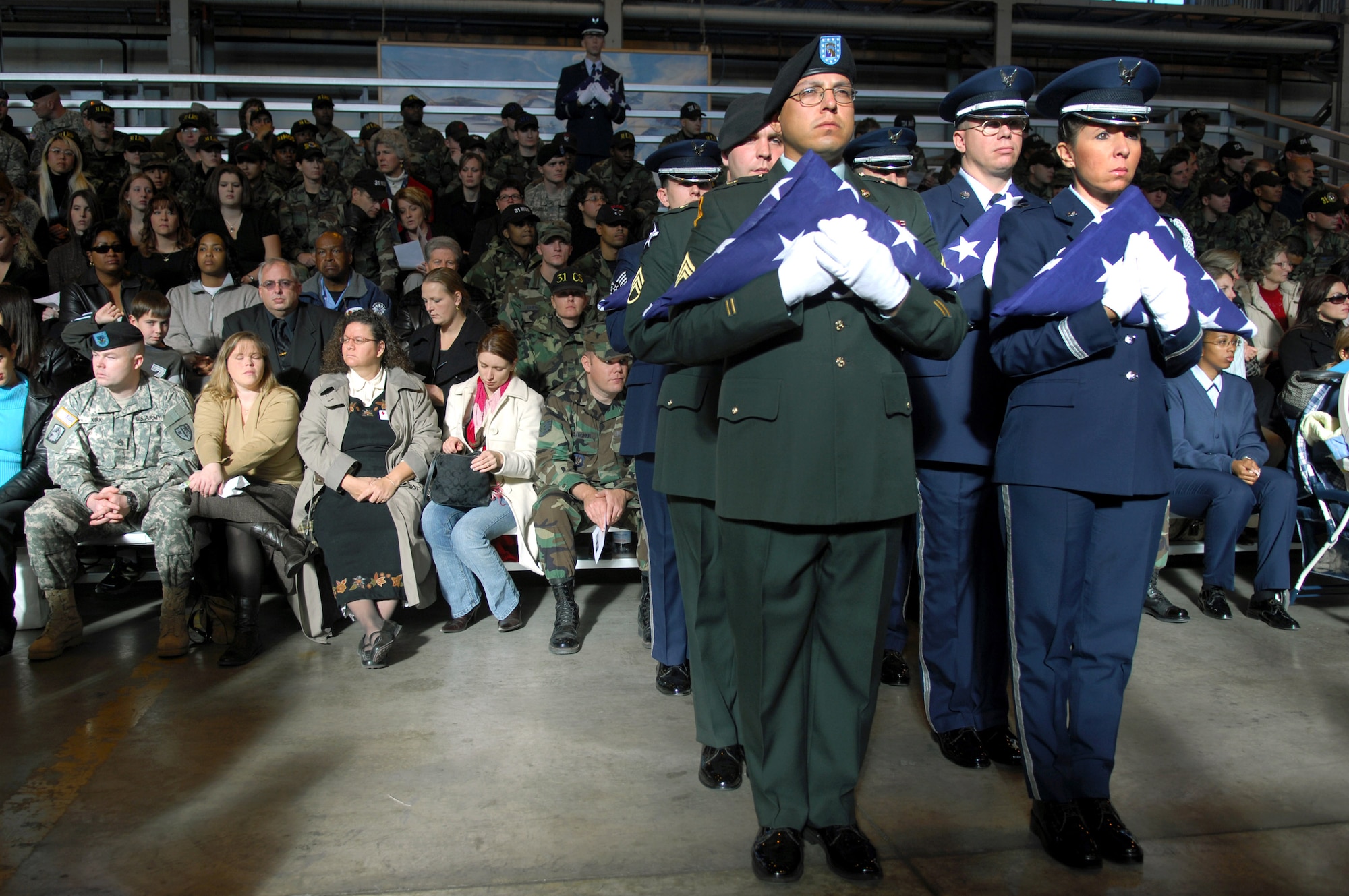 Air Force and Army honor guardsmen stand with folded flags during a memorial ceremony Nov. 15 at Aviano Air Base, Italy, in honor of the six servicemembers who were killed when a U.S. Army UH-60 Black Hawk helicopter attached to the 1st Battalion, 214th Aviation Regiment crashed Nov. 8, 22 miles southwest of Aviano, Italy. (U.S. Air Force photo/Staff Sgt. Michael R. Holzworth) 