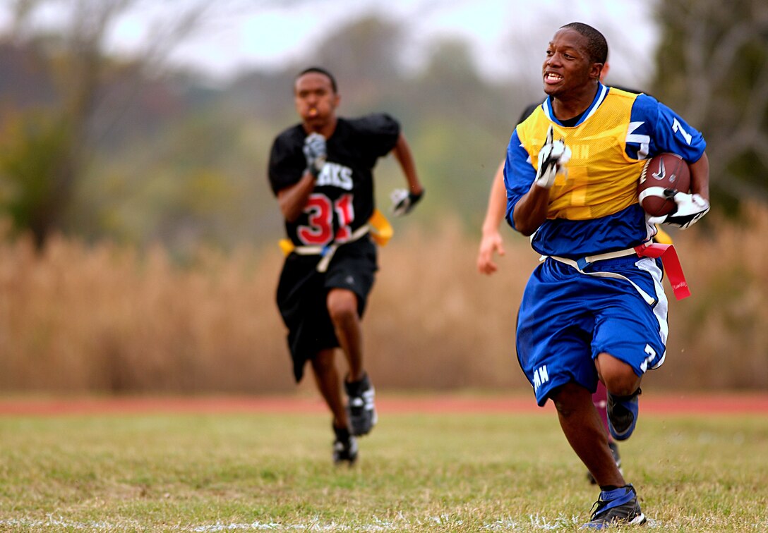 Brandon Davis (right) sprints down the sideline after an interception during the Langley Air Force Base Flag Football Championship Game.  Brandon Davis led the 1st Communications Squadron with one interception and fives as they defeated the 1st AMXS 19-13. (U.S. Air Force photo/Staff Sergeant Samuel Rogers) 