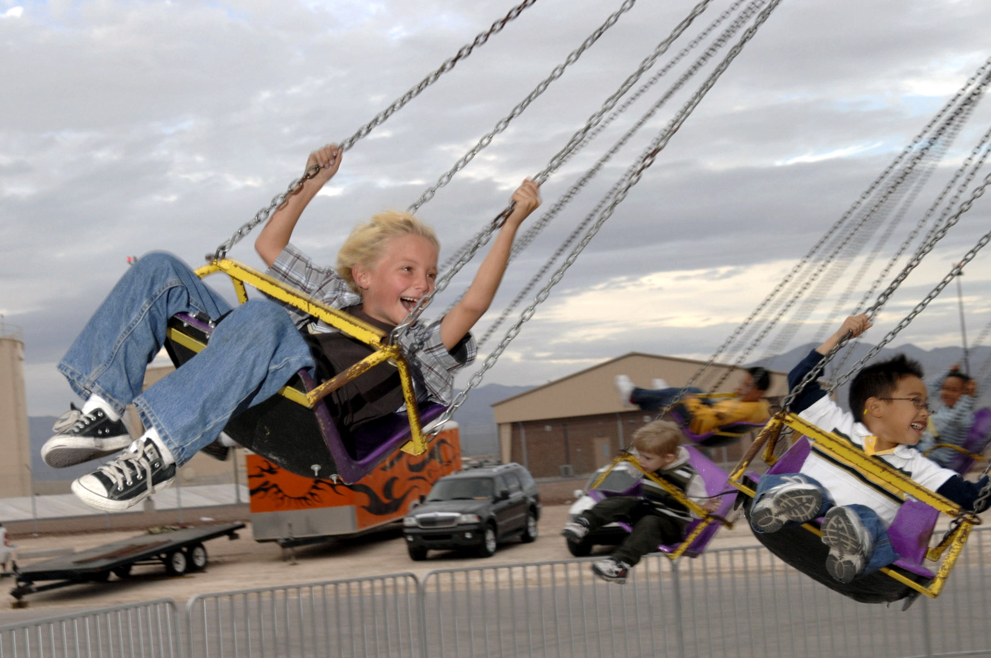 Jarod Worsley (left) enjoys a carnival ride during the Aviation Nation Air Show Nov. 11 at Nellis Air Force Base, Nev. Aviation Nation is one of the largest air shows in North America. This year's show commemorated 60 years of airpower and was the capstone event of the Air Force's yearlong 60th anniversary celebration. (U.S. Air Force photo/Master Sgt. Robert W. Valenca)
