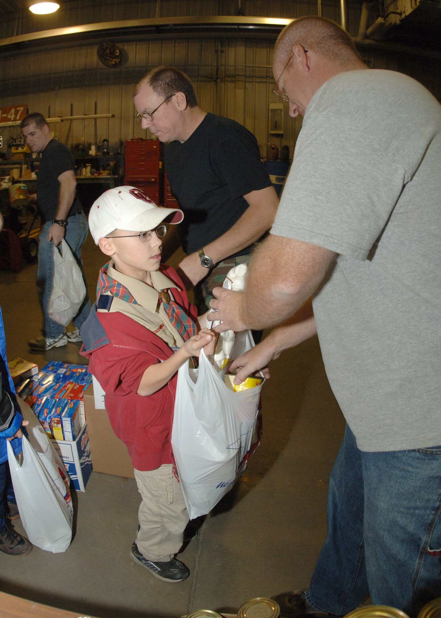 Rich Ewers (right) and Scott Alvar hand out assorted canned goods to scouts in the assembly line during Operation Warm Heart here Nov. 13. The Boy Scouts, Cub Scouts, Girl Scouts and first sergeants helped sort  thousands of canned goods and assembled 125 bagged meals during the event. (U.S. Air Force photo/Senior Airman Chad Kellum)     

 
