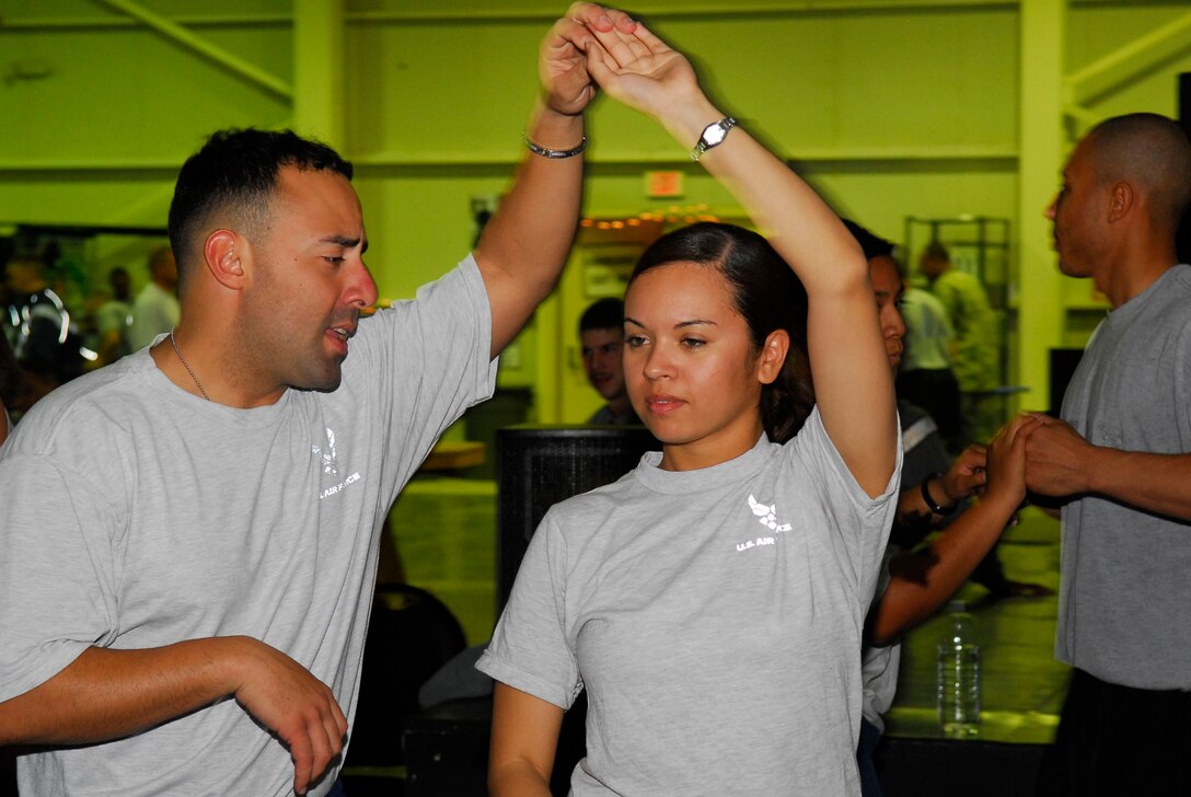 BALAD AIR BASE, Iraq -- Tech. Sgt. Aldomar Genao, 727th Expeditionary Air Control Squadron, dances the salsa with Senior Airman Christian Rodriguez, 332nd Expeditionary Mission Support Group Detachment 1, here, Nov. 14. Sergeant Genao volunteers his time to teach salsa to servicemembers at the Air Force recreation center. Sergeant Genao is deployed from Mountain Home Air Force Base, Idaho, and Airman Rodriguez is deployed from Travis AFB, Calif.  (U.S. Air Force photo/Staff Sgt. Joshua Garcia)