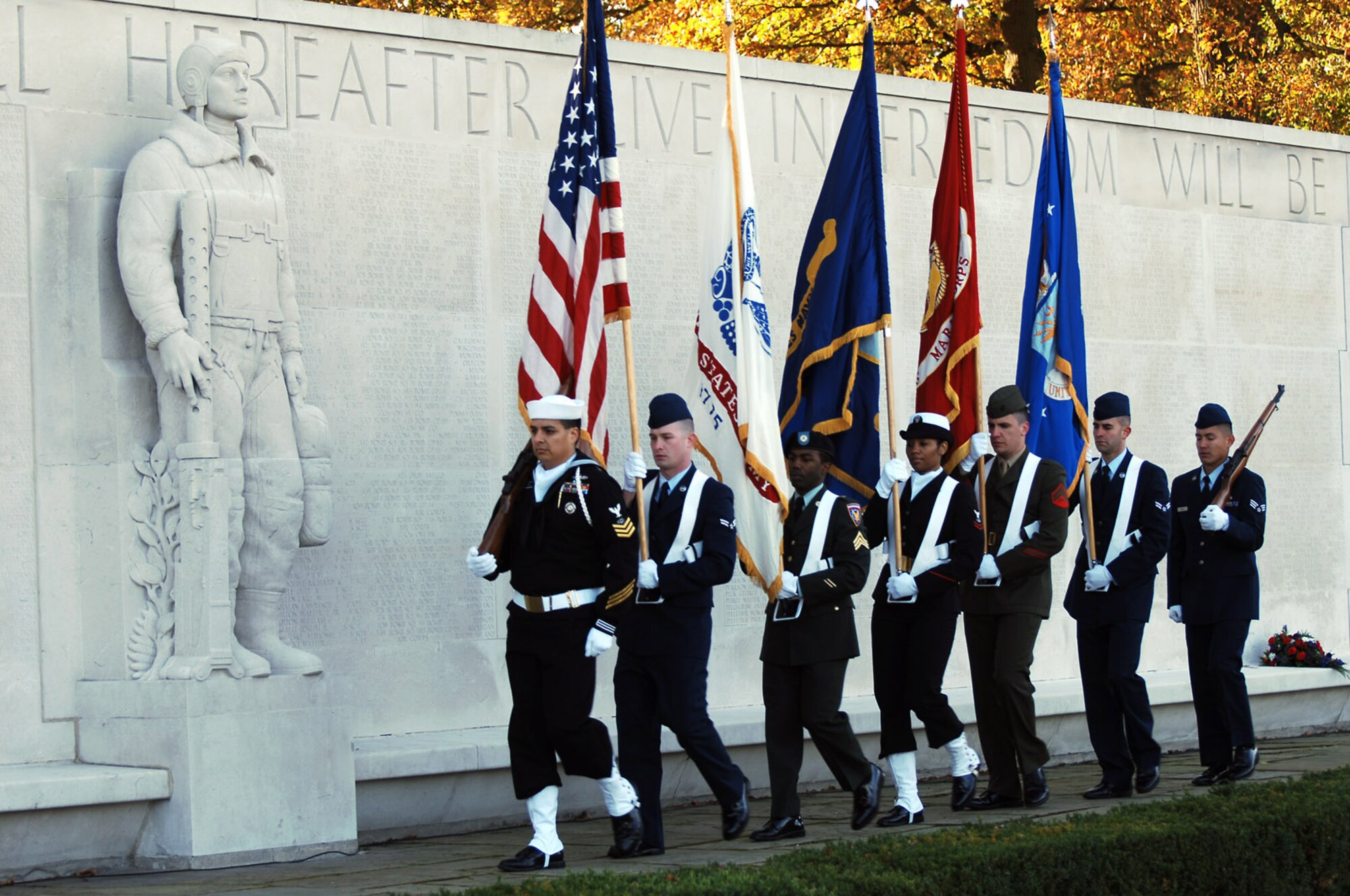 The Joint Analysis Center Color Guard from RAF Molesworth present the colors during the Veteran's Day Ceremony at the American Cemetery at Madingley. The Cemetery is the only WWII cemetery in the United Kigdom and has 3,812 American military members buried there. A stone memorial wall is inscribed with the names of 5,126 American who gave their lives in service of their country but whose remains were never recovered or identified. (U.S. Air Force photo by Staff Sgt. Chad Chisholm)