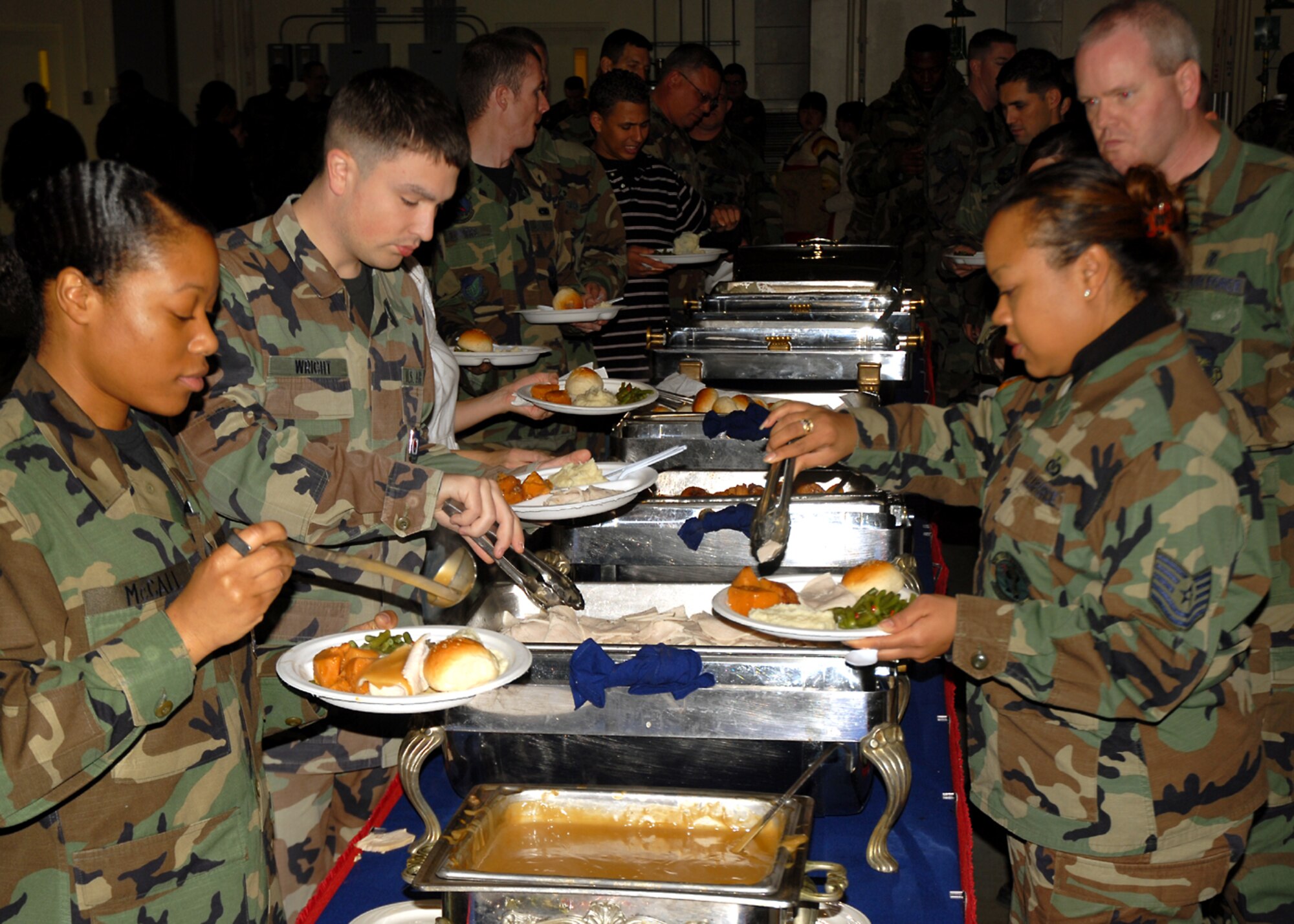 OSAN AIR BASE, Republic of Korea -- Osan Air Base Airmen go through the serving line during the 5th Annual Pre-Thanksgiving Day free luncheon sponsored by the USO and catered by the 51st Services Squadron.  Over 500 Airmen enjoyed Turkey and complementary sides during this year's event held at the base fire department .  (U.S. Air Force Photo by Senior Master Sgt. Marvin Krause)