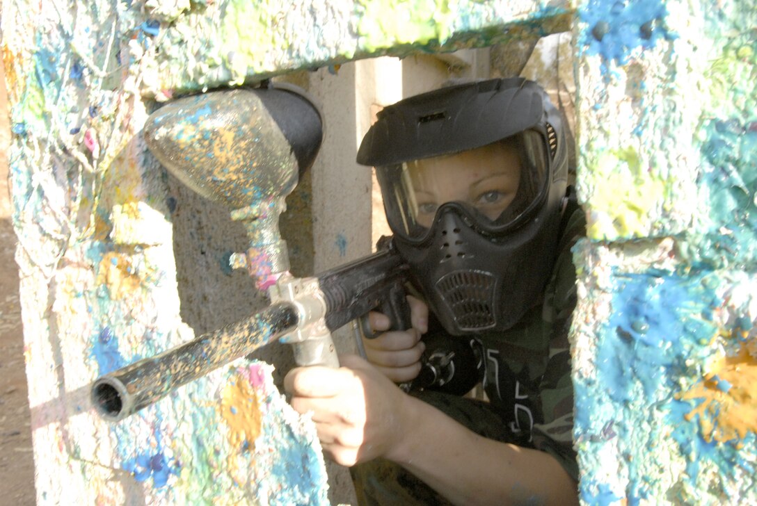 Marine spouse Chasity Terry aims through a window at an opposing player at Mr. Paintball USA, Escondido, Calif., Nov. 16. Fifteen wounded warriors with Naval Medical Center San Diego were given an opportunity to play paintball for free to aid them through their emotional and physical recovery. Event organizers were skeptical about hosting a paintball event for the wounded warriors as they thought it might emotionally affect them because of their combat experiences. According to some of the players, the event was therapeutic.