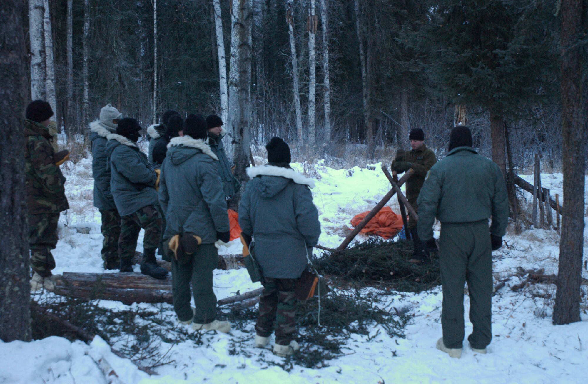 EIELSON AIR FORCE BASE, Alaska-- Staff Sgt. Jason Clapper, Det. 1, 66th Training Squadron Arctic Survival Instructor, demonstrates the correct position of tree branches for the base of a shelter to a class of U.S Air Force members of Eielson and Elmendorf Air Force Bases during the second day of the Arctic Survival Training Course Nov. 15, 2007.  The survival course teaches members how to survive in a severe cold climate. The course consists of shelter building, identifying safe food found in nature, how to stay warm, and how to correctly signal for help. The Arctic Survival Course is conducted at Eielson AFB by Survival Evasion Resistance and Escape specialists of Det. 1, 66th TRS. (U.S Air Force photo by Staff Sgt Eric T. Sheler)