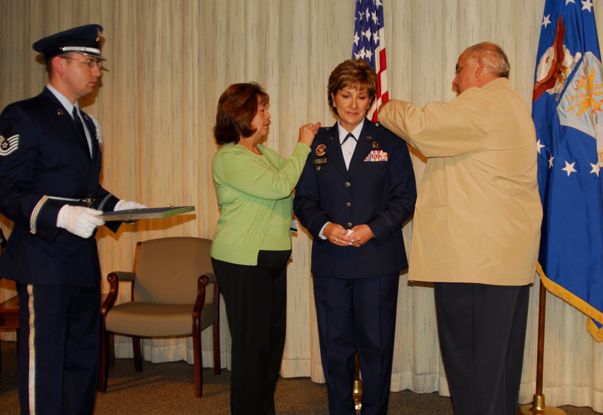 MaryAnn and retired Master Sgt. Reymundo Lopez pin eagles onto their daughter, Col. Laura Lopez during a ceremony in the Webber Auditorium on Nov. 16. Colonel Lopez is the assignment actions division chief in DPA. (U.S. Air Force photo/Ellen Edwards)