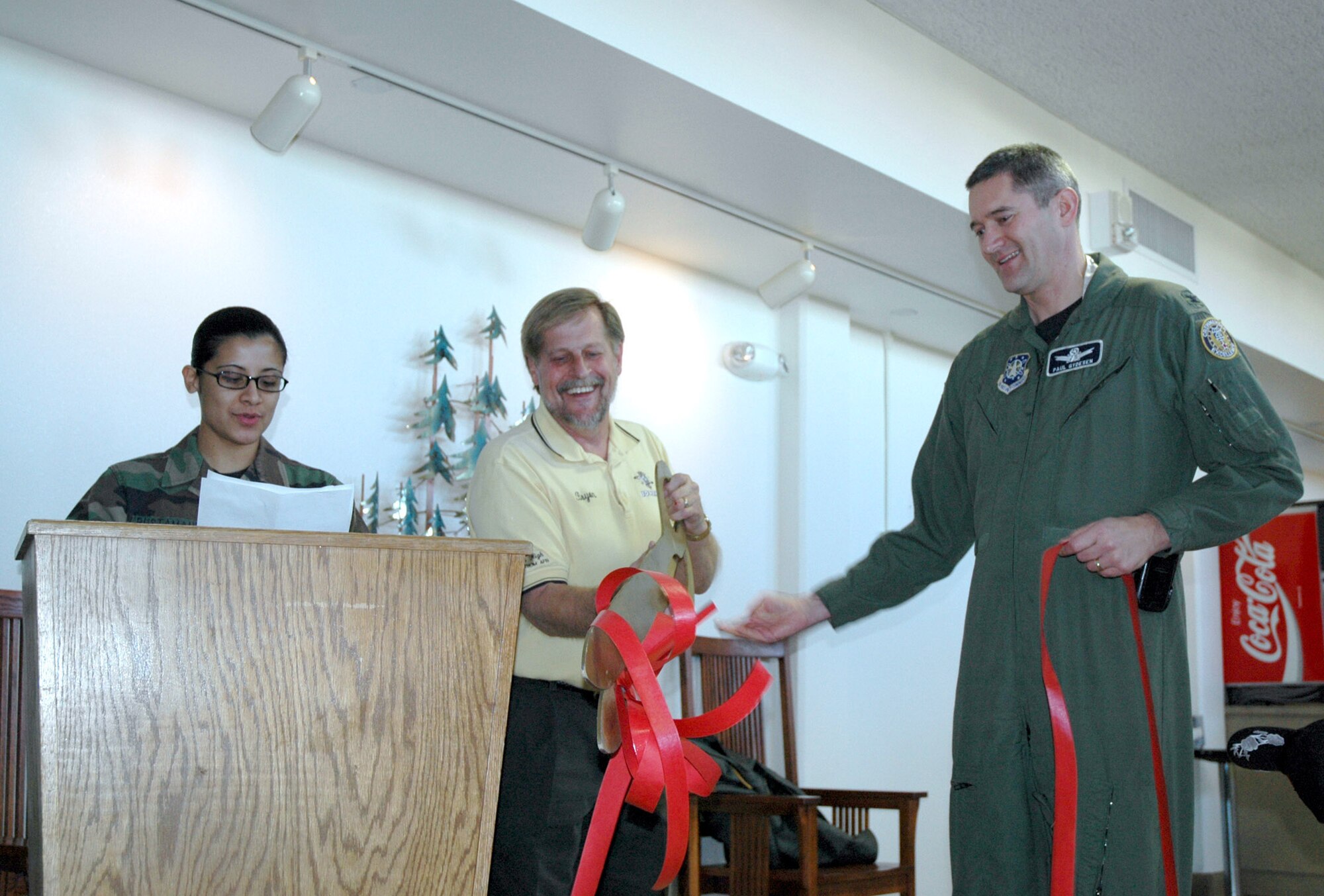 Col. Paul Gydesen, 341st Space Wing vice-commander, right, holds the ribbon while Bryon Mullett, manager of the Aces High Bowling Center, cuts the ribbon at the re-opening of the base auditorium and movie theater Nov. 16. Staff Sgt. Sonia Bustamonte, 341st Services Squadron, left, was the emcee for the event. The theater received a major facelift to the exterior of the building along with new a heating, ventilation and air conditioning system. For movie schedules and information, Team Malmstrom can visit www.341services.com or call the hotline at 731-3236. The base auditorium plays free movies each weekend.  (U.S Air Force photo/Senior Airman Eydie Sakura)