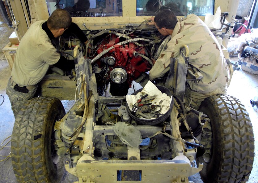 Tech. Sgt. James Nelson and Staff Sgt. Logan Pike work on the wiring harness of a Humvee Nov. 1 at forward operating base Lagman, Afghanistan. Sergeants Nelson and Pike are filling 365-day Army 'in-lieu-of' taskings.  Sergeant Nelson is deployed from Nellis Air Force Base, Nev., while Sergeant Pike is deployed from Malmstrom AFB, Mont. (U.S. Air Force photo/Staff Sgt. Brian Ferguson)