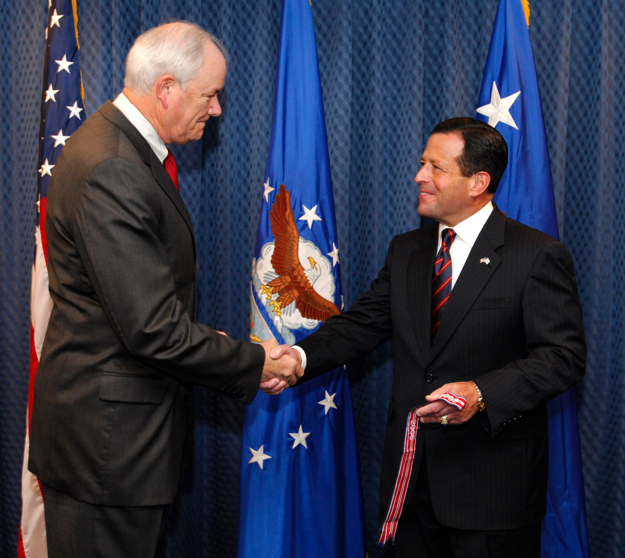 Secretary of the Air Force Michael W. Wynne (left) congratulates Bruce Lemkin, deputy undersecretary of the Air Force for International Affairs, at an award ceremony at the Pentagon Nov. 15. The members of SAF/IA were honored with the Air Force Organizational Excellence Award. (U.S. Air Force photo/Michael Pausic)