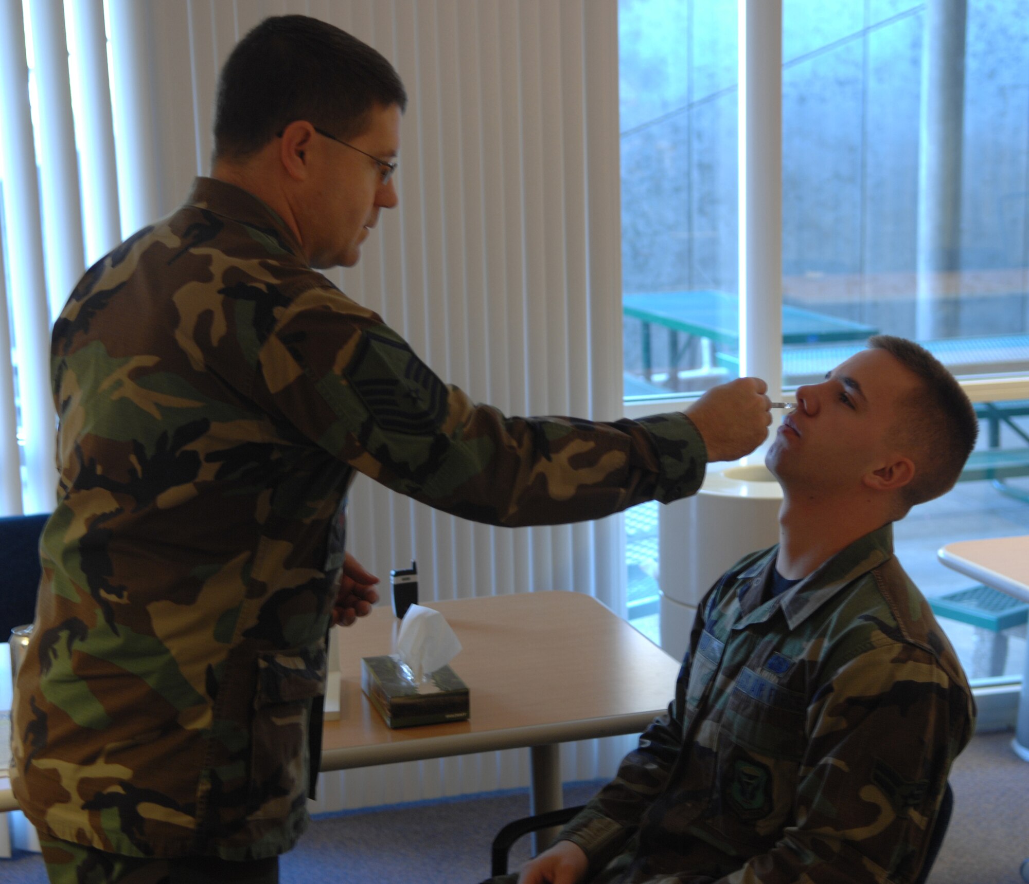 WHITEMAN AIR FORCE BASE, Mo. - Airman 1st Class Cory Todd, 509th Bomb Wing Public Affairs, receives  a FluMist vaccination from Master Sgt. Matt St. Pierre, 509th Medical Operations Squadron, Nov. 16 at the base clinic. Active duty members are require to receive either the FluMist or a flu shot. For more information, call the immuzations clinic at 687-4304. (U.S. Air Force photo/Airman 1st Class Stephen Linch)

