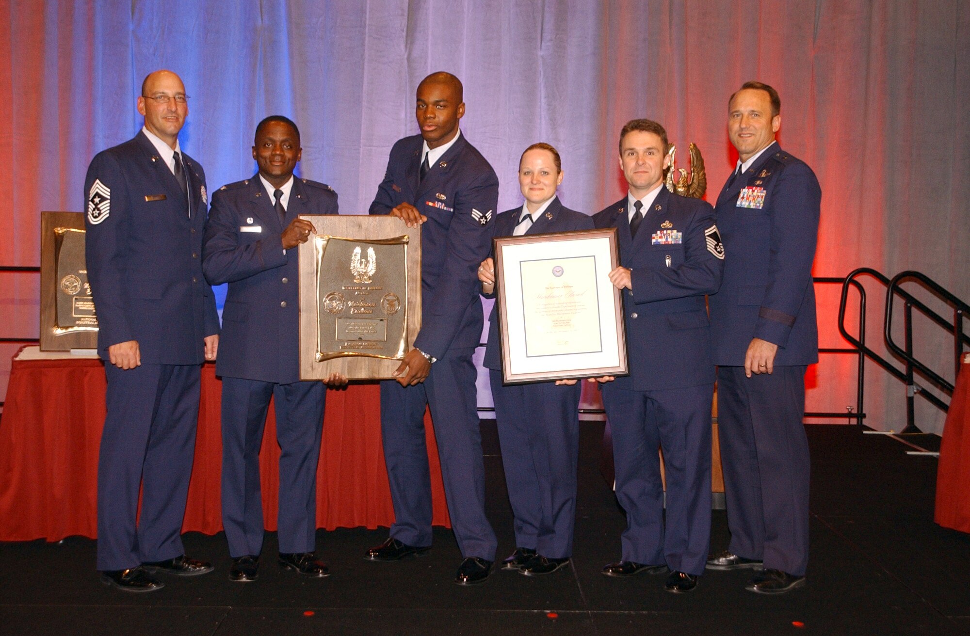 FROM LEFT: Chief Master Sgt. Mitchell Stippel, Col. Algene Fryer, Senior Airman Ntungwe Sobe, Tech. Sgt. Lynette Castillo, Senior Master Sgt. Darren Dykes and Brig. Gen. Tom Jones stand holding the hardware they received at the Department of Defense Maintenance Awards ceremony Nov. 15 in Orlando, Fla. The award named Luke’s 56th Maintenance Group as one of the DOD’s top six maintenance organizations for 2007. (photo by 2nd Lt. Bryan Bouchard)