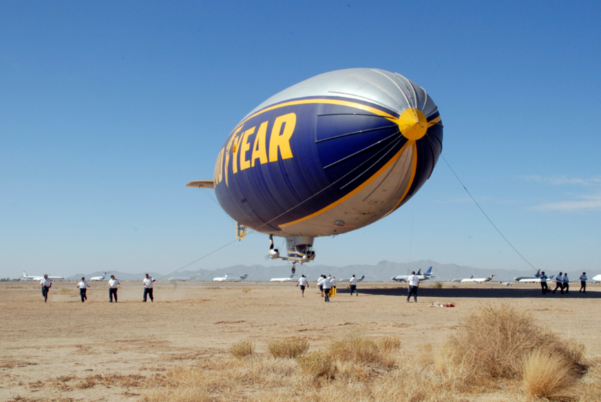 Ground crew members for the Goodyear Blimp secure the blimp as it comes in for a landing Nov. 12. The twin engine, lighter-than-air blimp can hold up to six passengers
and one pilot. Ground crew members stabilize the airship while passengers load and unload. The blimp was in town for the weekend for the NASCAR Checker Auto Parts 500 at Phoenix International Raceway. (photo by Airman 1st Class Tracy Forte)