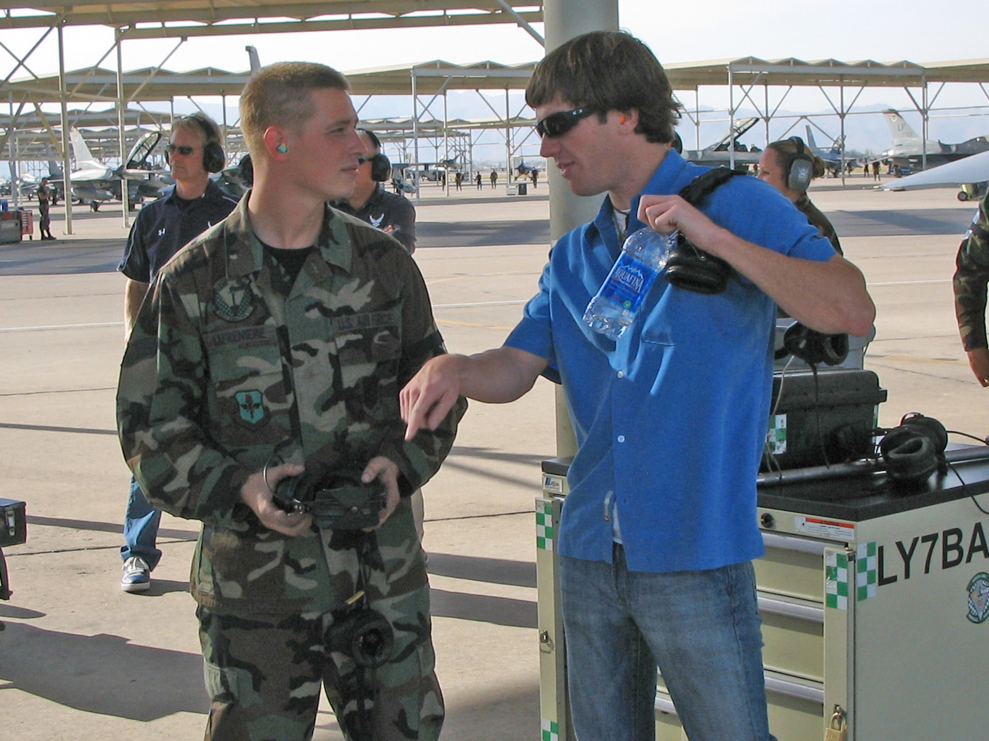 NASCAR driver Jon Wood talks about his racing experiences with Senior Airman William Lafreniere, 756th Aircraft Maintenance Squadron crew chief. Wood visited Luke Nov. 7 to meet with 56th Fighter Wing Airmen, familiarize himself with the base and sign autographs at the base exchange. He is the driver of the No. 21 Air Force car. On Friday he raced in the NASCAR Craftsman Truck Series race and finished  eighth. (photo by Tech. Sgt. Robert Zoellner)