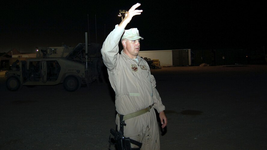 Master Sgt. Steven Miller gives the signal to move a convoy out Nov. 12 at Camp Bucca, Iraq. Sergeant Miller, an 887th Expeditionary Security Forces convoy commander, is from Moody Air Force Base, Ga. (U.S. Air Force photo/Staff Sgt. Phillip Butterfield) 