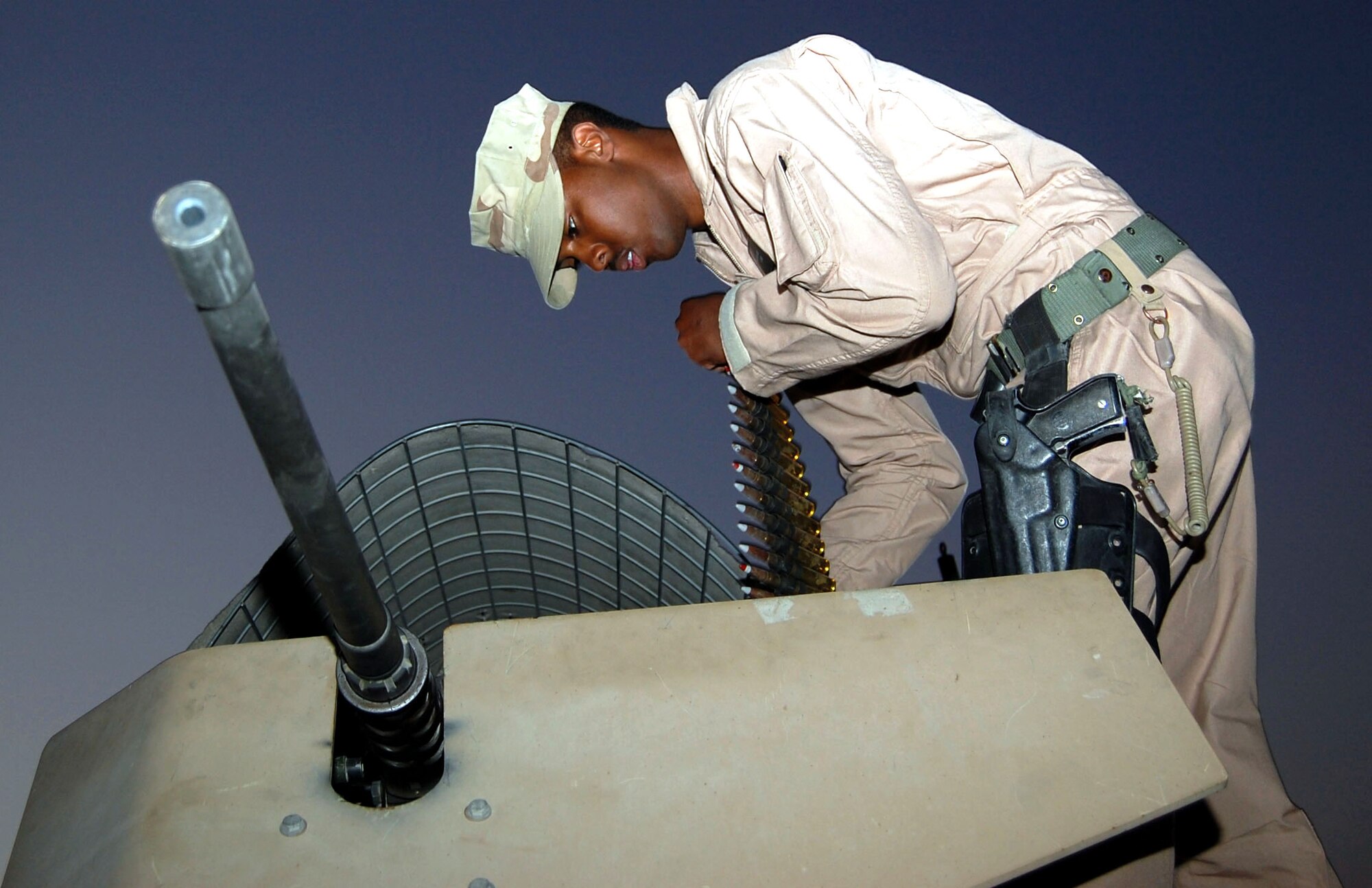 Airman 1st Class Bryson Cornelius feeds 50 caliber ammunition into a storage container Nov. 12 at Camp Bucca, Iraq. Airman Cornelious, an 887th Expeditionary Security Forces Punisher Squad gunner, is stationed at Lackland Air Force Base, Texas. He operates the M-2 heavy machine gun during convoy operations. (U.S. Air Force photo/Staff Sgt. Phillip Butterfield) 
