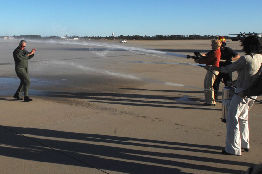 Lt. Gen. Michael Wooley, Air Force Special Operations Command commander, is sprayed with a water hose by his wife, Kathy, and a fire extinguisher by his secretary, Tracy Norrad, following his finis, or final, flight Nov. 15 on the Hurlburt Field fliight line. General Wooley will relinquish command of AFSOC to Maj. Gen. Donnie Wurster Nov. 27. (U.S. Air Force Photo/Senior Airman Stephanie Jacobs)