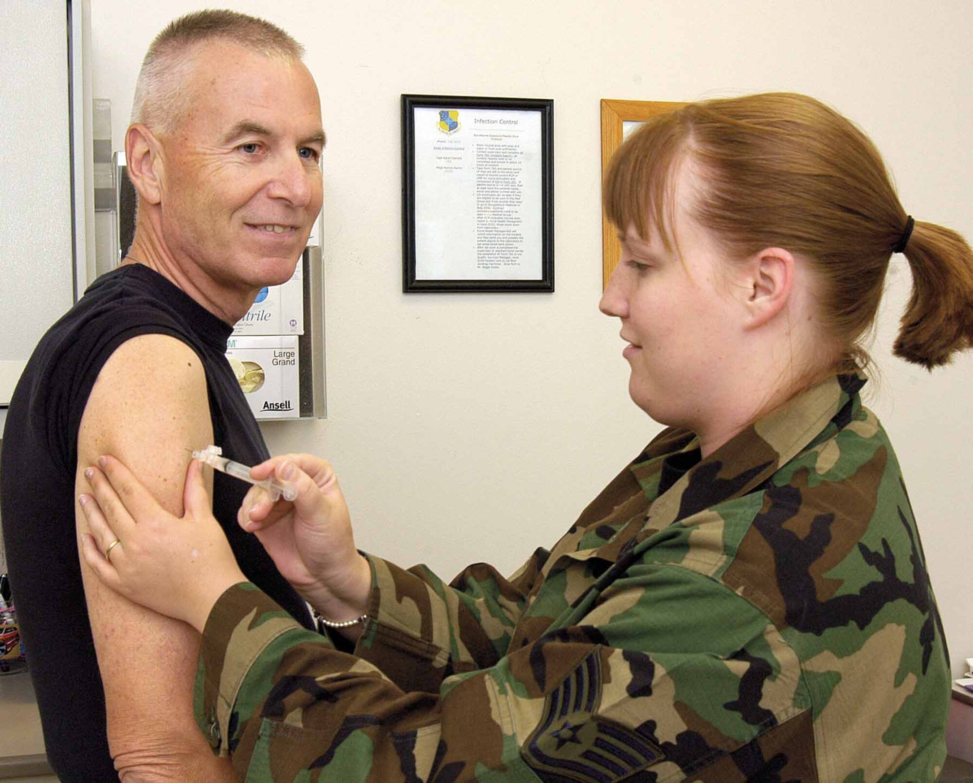 Col. Roger Goetz, 72nd Medical Group commander, gets a flu shot recently from Staff Sgt. Tiffany Gordon, noncommissioned officer in charge of the Immunizations Clinic.  All active duty military are required to have the annual vaccine. (Air Force photo by Margo Wright)