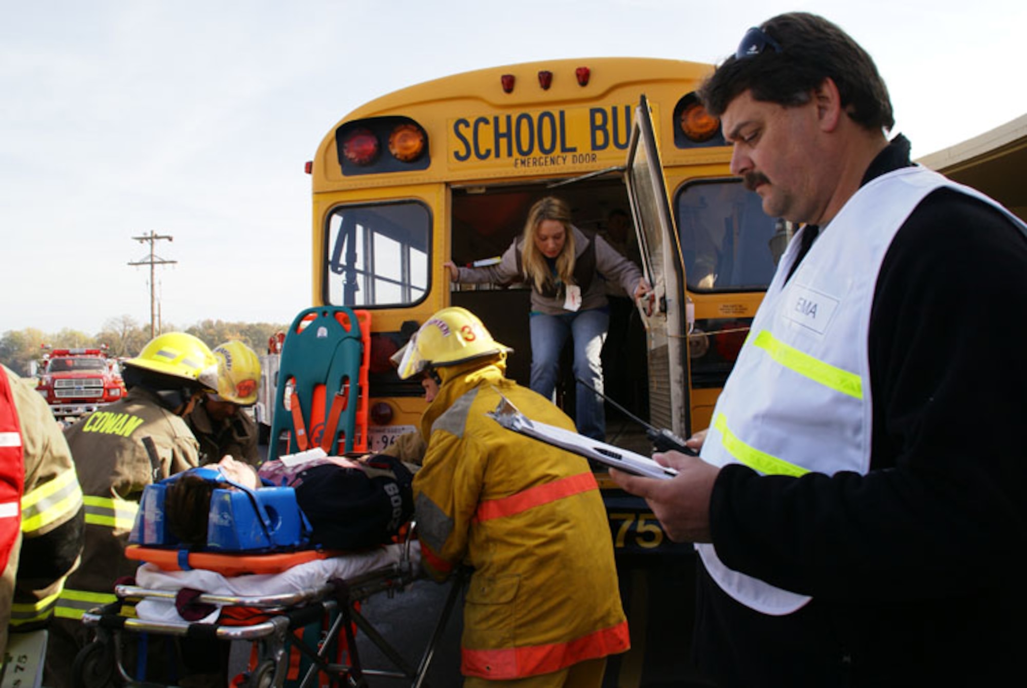 From right, Eric Trussell, director of Franklin County’s Emergency Management Agency, checks an emergency response roster of participants while Cowan fire department first responders transport an injured middle school student to an ambulance to one of three area hospitals during the exercise. (Photo by Philip Lorenz III)