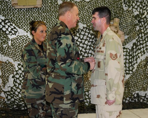 MINOT AIR FORCE BASE, N.D. -- Col. Joel Westa (center), 5th Bomb Wing commander, pins an Air Force Combat Action Medal on Staff Sgt. Scott Lilley, 5th Security Forces Squadron, for his courageous efforts while deployed to Iraq. Sergeant Lilley was one of two Airmen here to recently receive the award. (U.S. Air Force photo by Airman 1st Class Joe Rivera)