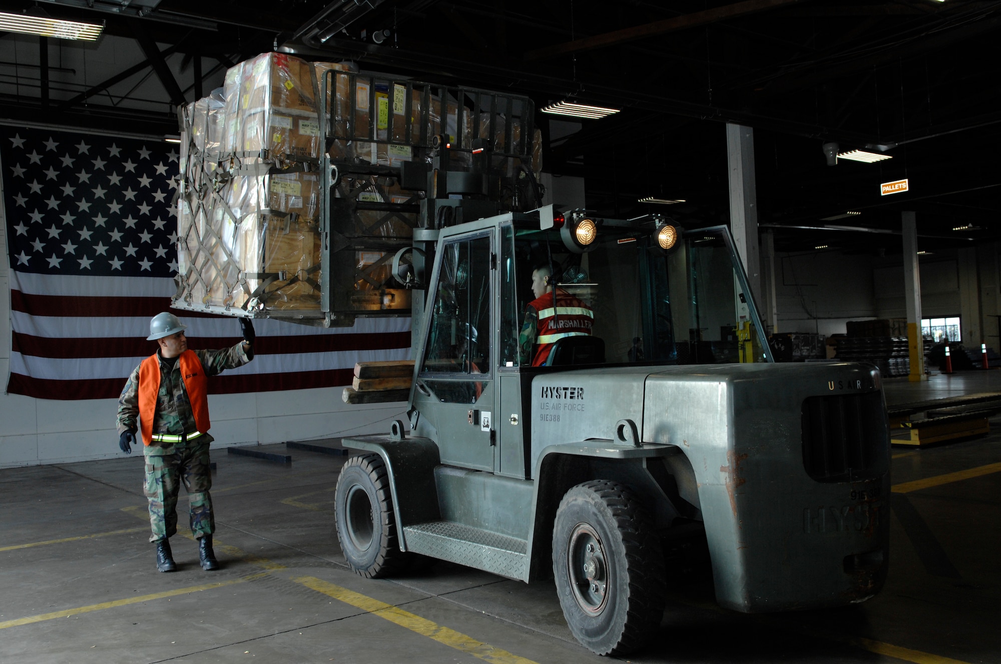 Staff Sgt. Wesley Lindsey, 28th Civil Engineer Squadron cargo in-checker, inspects the cargo while it's being marshaled into the cargo deployment function by Senior Airman Steven Wachlin, 28th Services Squadron, during an Operational Readiness Inspection at Ellsworth Air Force Base, S.D., Nov. 15, 2007. The cargo deployment function is responsible for ensuring all cargo is properly documented and secured for transportation.(U.S. Air Force photo/Senior Airman Angela Ruiz)