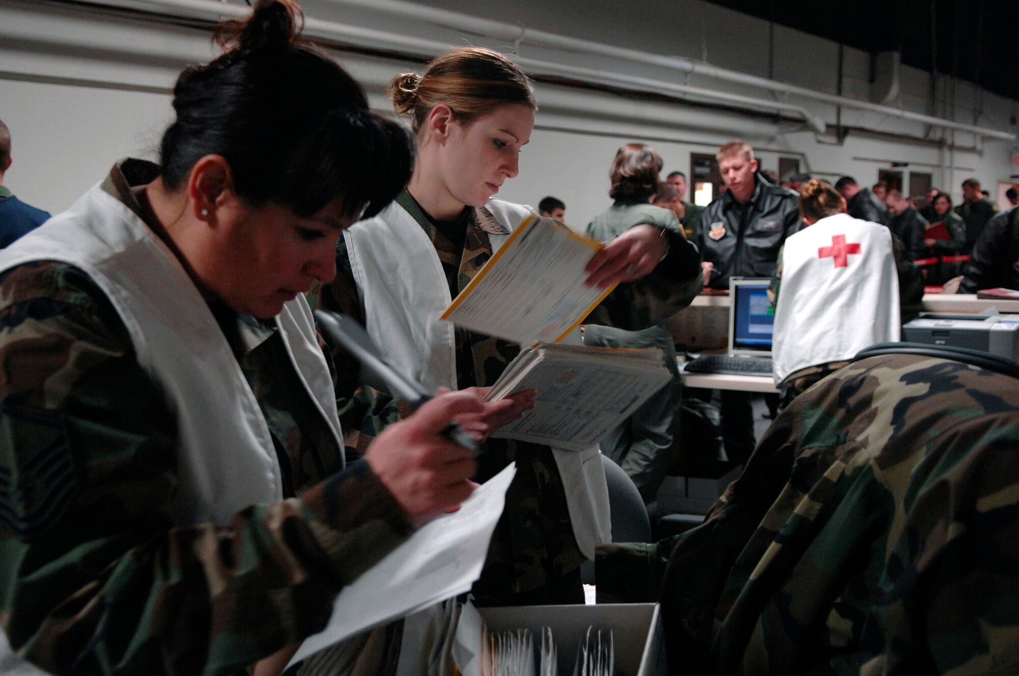 U.S. Air Force Master Sgt. Candy Malley, left, and Airman 1st Class Martha Shaw, both from the 28th Medical Operations Squadron, sort through medical records as 28th Bomb Wing members process through a simulated deployment line during Operational Readiness Inspection (ORI) Coronet White 07-ACC-12 at Ellsworth Air Force Base, S.D., Nov. 15, 2007.  An Air Combat Command inspection team will use this ORI to evaluate Ellsworth's ability to effectively and rapidly deploy.  (U.S. Air Force photo by SSgt Michael B. Keller)(Released)

