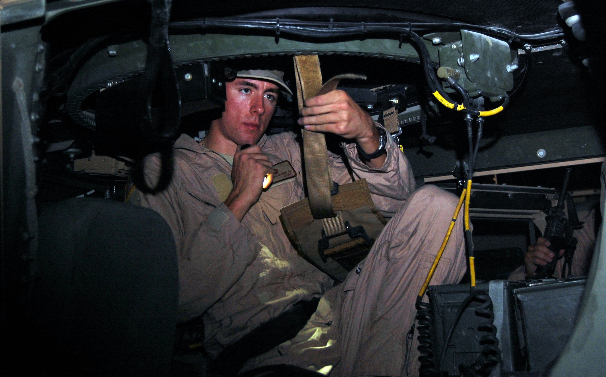 SOUTHWEST ASIA – Airman 1st Class Byron Mcguire, 887th Expeditionary Security Forces Cobra Squad gunner, inspects the straps on the turret seat prior to a mission Nov. 12 at Camp Bucca, Iraq. Airman Mcguire is from Moody Air Force Base, Ga. (Air Force Photo/Staff Sgt. Phillip Butterfield)



