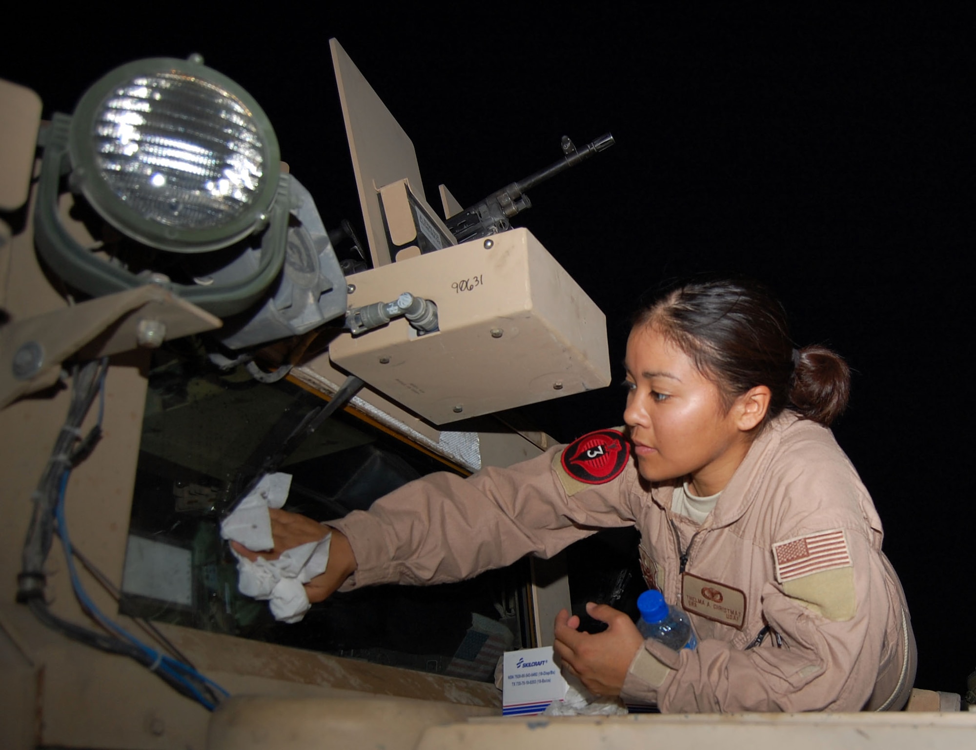 SOUTHWEST ASIA – Senior Airman Thelma Christmas, 887th Expeditionary Security Forces Cobra Squad driver, cleans the ballistic windshield of a humvee prior to taking it on the road Nov. 12 at Camp Bucca, Iraq. Airman Christmas is from Moody Air Force Base, Ga. (Air Force Photo/Staff Sgt. Phillip Butterfield)


