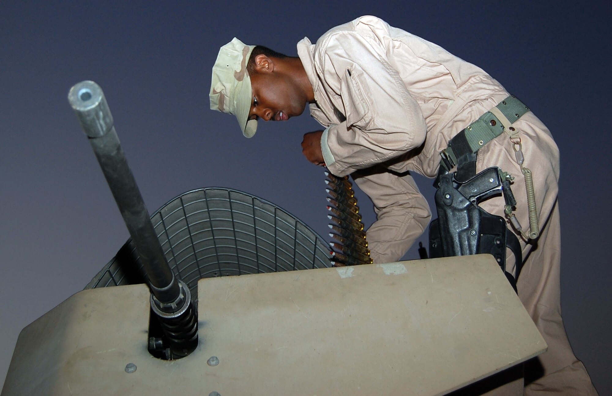 SOUTHWEST ASIA – Airman 1st Class Bryson Cornelius, 887th Expeditionary Security Forces Punisher Squad gunner, feeds 50 caliber ammunition into a storage container Nov. 12 at Camp Bucca, Iraq. Airman Cornelious who is stationed at Lackland Air Force Base, Texas, operates the M-2 heavy machine gun, a weapon that has been in the U.S. military’s inventory since 1933. (Air Force Photo/Staff Sgt. Phillip Butterfield)

