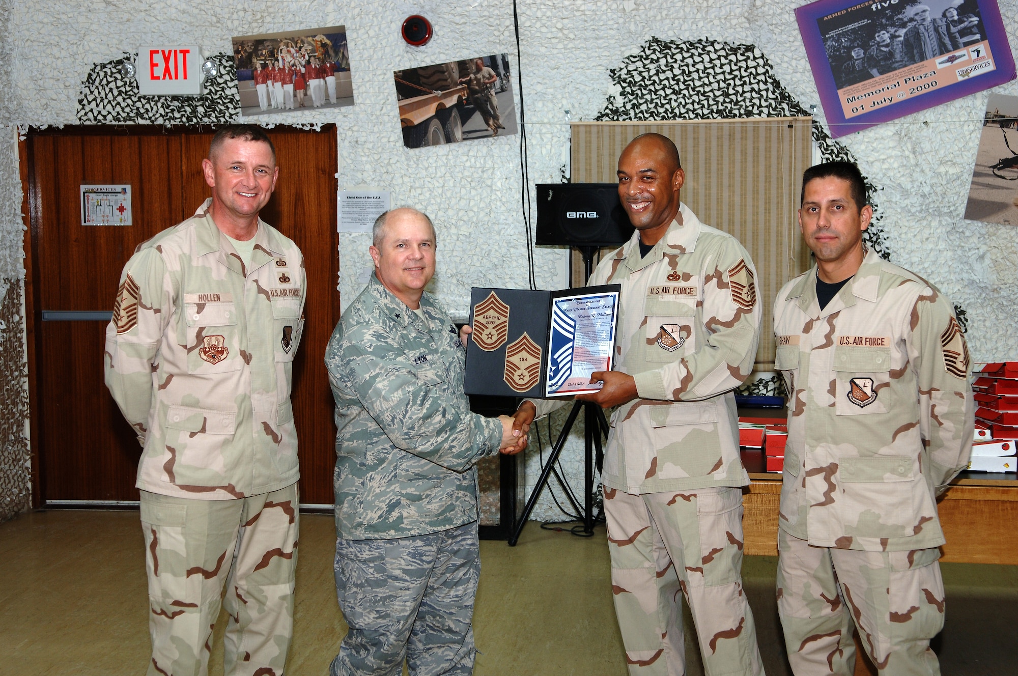 SOUTHWEST ASIA - Senior Master Sgt. Rodney Phillips, 379th Expeditionary Logistics Readiness Squadron, is presented a certificate of congratulations Nov.15  by Brig. Gen. Charles Lyon, 379th Air Expeditionary Wing commander, for his selection to the grade of chief master sergeant. Standing by are Chief Master Sgts. Lloyd Hollen, 379th AEW command chief and Roger Shaw, 379th ELRS. (Air Force photo/Master Sgt. Greg Kunkle)




