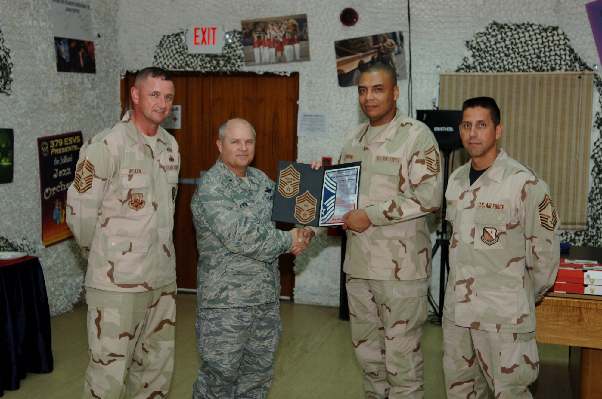 SOUTHWEST ASIA - Senior Master Sgt. Larry Osborne, 379th Expeditionary Maintenace Group, is presented a certificate of congratulations Nov.15  by Brig. Gen. Charles Lyon, 379th Air Expeditionary Wing commander, for his selection to the grade of chief master sergeant. Standing by are Chief Master Sgts. Lloyd Hollen, 379th AEW command chief and Roger Shaw, 379th Expeditionary Logistics Readiness Squadron. (Air Force photo/Master Sgt. Greg Kunkle)



