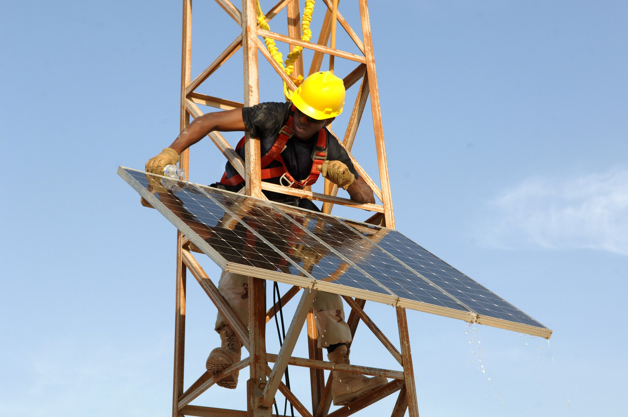SOUTHWEST ASIA - Staff Sgt. Tariq Simpson, 379th Expeditionary Communications Squadron, inspects and cleans a solar panel that helps to power the Giant Voice at a base in Southwest Asia. Sergeant Simpson is deployed from Lackland AFB, Texas.
(Air Force Photo/Master Sgt. Greg Kunkle)
