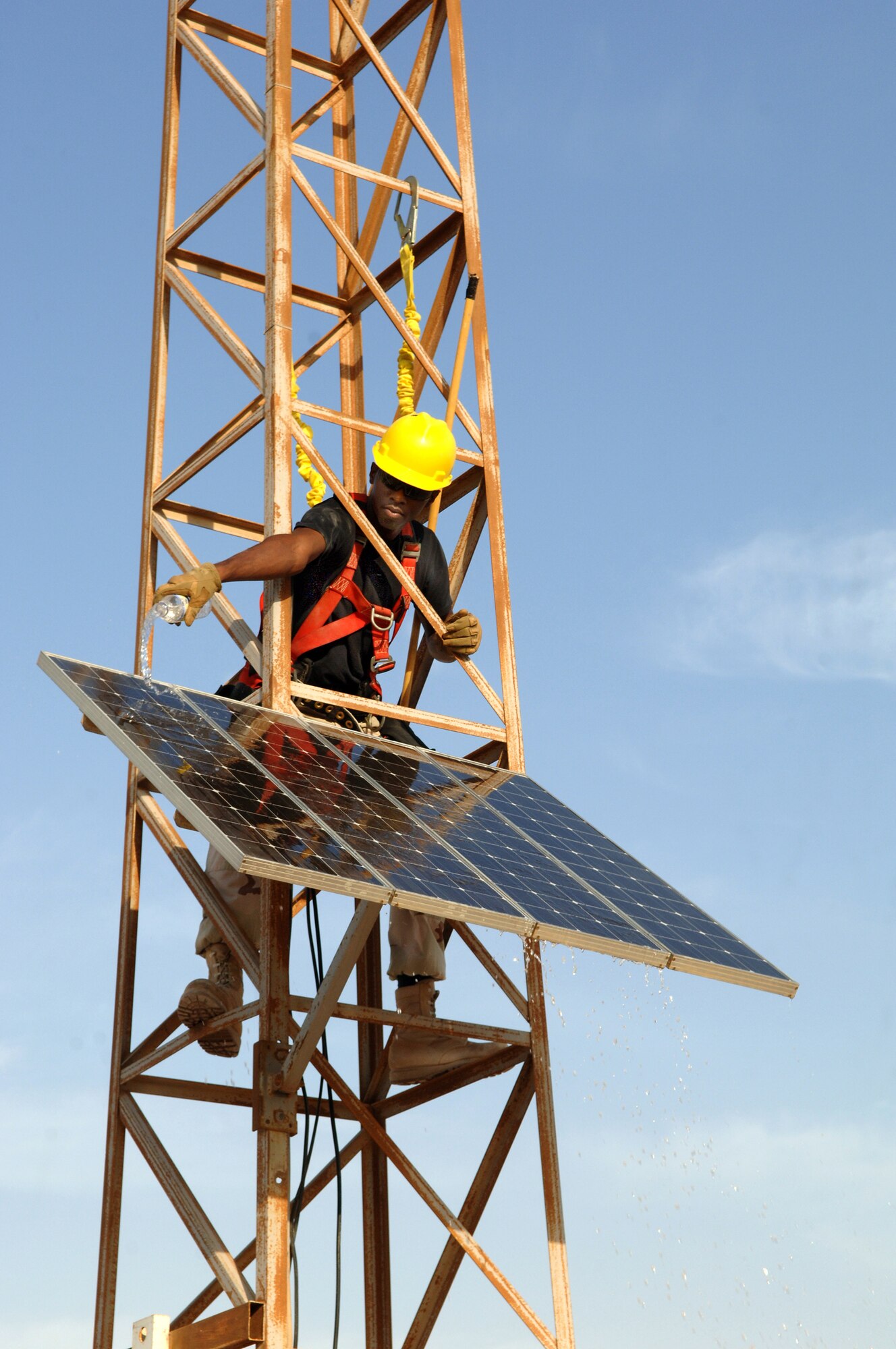 SOUTHWEST ASIA - Staff Sgt. Tariq Simpson, 379th Expeditionary Communications Squadron, inspects and cleans a solar panel that helps to power the Giant Voice at a base in Southwest Asia. Sergeant Simpson is deployed from Lackland AFB, Texas.
(Air Force Photo/Master Sgt. Greg Kunkle)