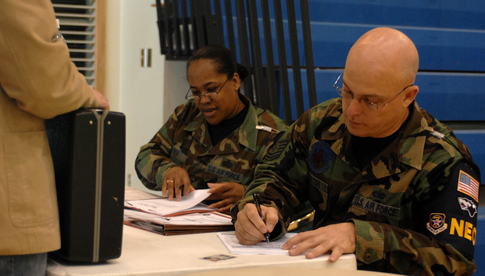 KUNSAN AIR BASE, South Korea – Master Sgt. Grace Hooks and Tech. Sgt. Brain Shelton, noncombatant evacuation operations (NEO) exercise wardens register noncombatants for evacuation during Courageous Channel here Nov. 16.  Courageous Channel is a semi-annual NEO exercise conducted to test the command's plans and procedures for a short-notice evacuation from the Republic of Korea.  (U.S. Air Force photo/ TSgt Quinton T. Burris)