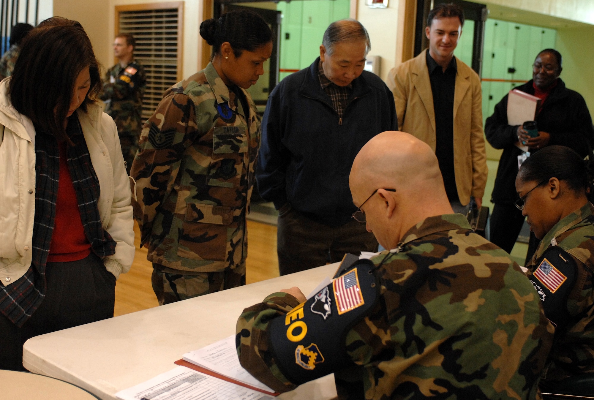 KUNSAN AIR BASE, South Korea – Tech. Sgt. Brain Shelton and Master Sgt. Grace Hooks, noncombatant evacuation operations (NEO) exercise wardens register noncombatants for evacuation during Courageous Channel here Nov. 16.  Courageous Channel is a semi-annual NEO exercise conducted to test the command's plans and procedures for a short-notice evacuation from the Republic of Korea.  (U.S. Air Force photo/ TSgt Quinton T. Burris)
