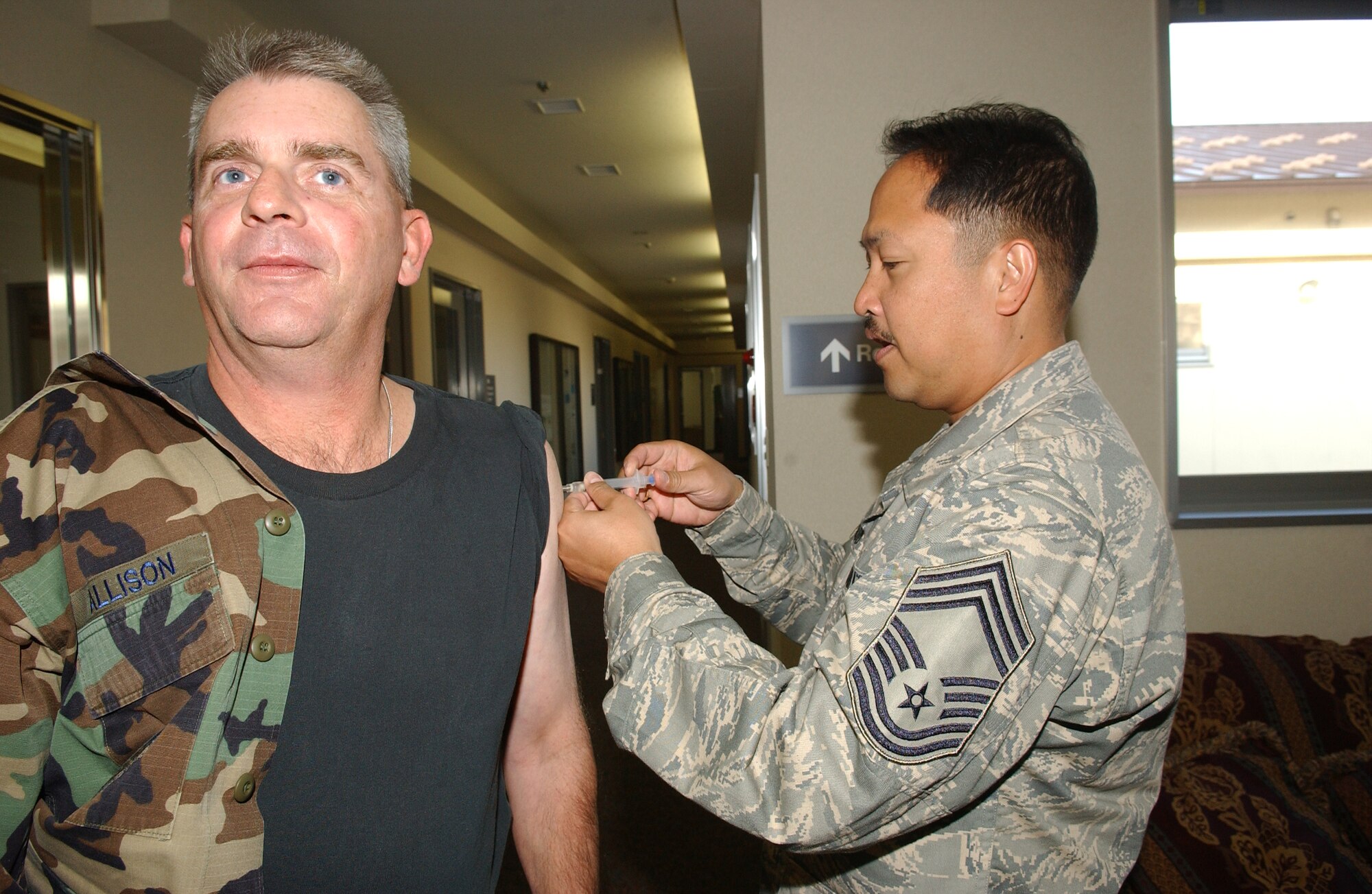 MISAWA AIR BASE, Japan - Chief Master Sgt. Brett Allison, 35th Operations Group, received his annual flu shot from Chief Master Sgt. James Inaldo, 35th Medical Group, at the 35th Fighter Wing Headquarters on Nov. 15, 2007.  Flu vaccines are now available to the Misawa community. (U.S. Air Force photo by Senior Airman Robert Barnett)