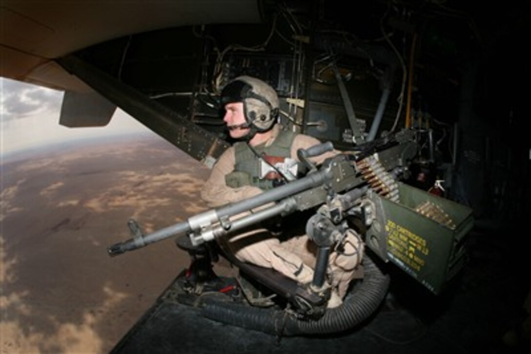U.S. Marine Corps Sgt. Joshua DeBoer mans a machine gun in the back of a MV-22B Osprey aircraft while flying over Iraq on Oct. 18, 2007.  DeBoer is a crew chief with Marine Medium Tiltrotor Squadron 263.  