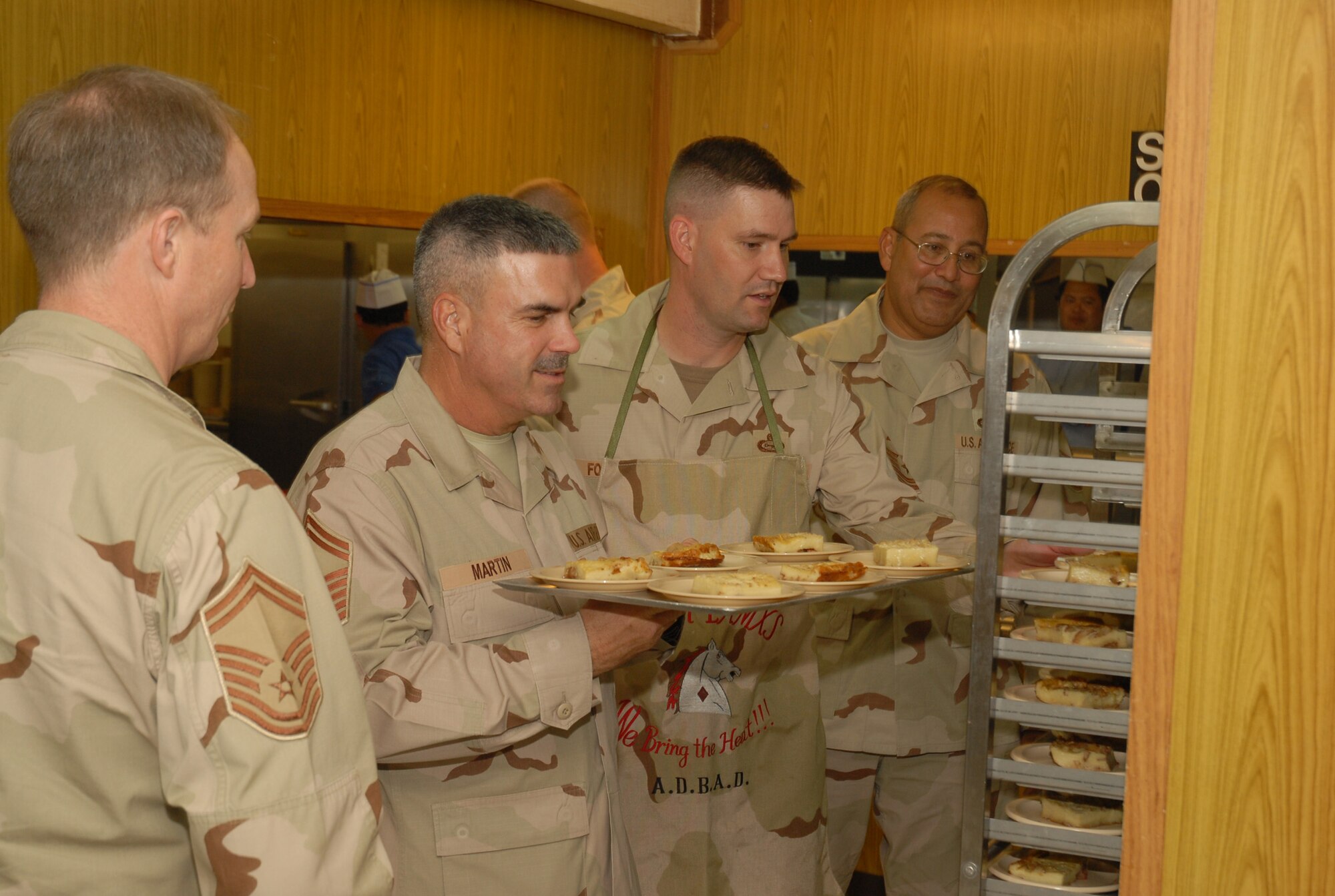 SOUTHWEST ASIA - Senior noncommissioned officers at an air base in Southwest Asia prepare to serve dessert Nov. 13 to all servicemembers celebrating birthdays in the month of November. The birthday dinner is hosted monthly for any servicemembers that may be celebrating birthdays within that month. (U.S. Air Force photo/Staff Sgt. Douglas Olsen)