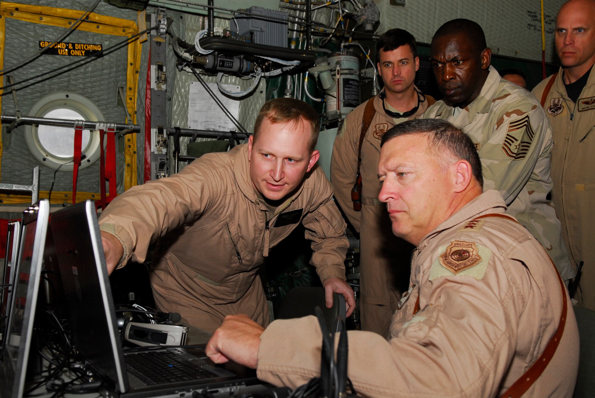 BALAD AIR BASE, Iraq -- Petty Officer 1st Class Nels Thorsen, a Joint Airborne Battle Staff mission controller from 777th Expeditionary Airlift Squadron, discusses the mission of the Joint Airborne Communications System
on a C-130 Hercules with Lt. Gen. Gary North, Combined Forces Air Component Commander, here, Nov. 16. The JACS is an airborne command and control and communication station that provides communications relay improving battlefield awareness for ground convoy forces. Petty Officer Thorsen is a U.S. Navy Individual Augmentee from the Naval Air Technical Training Center
in Pensacola, Fla. (U.S. Air Force photo/Staff Sgt. Joshua Garcia)