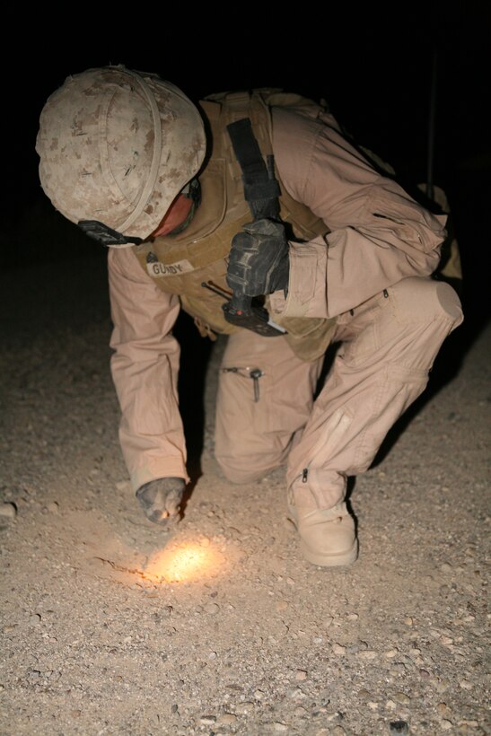AL ASAD, Iraq (Nov. 19, 2007) ? Sgt. Levi A. Gundy probes the ground in an area marked by a metal detector Nov. 19.  The members of an Obstacle Clearing Team were clearing the area of anything that would prevent Naval Mobile Construction Battalion 15 from repairing craters.  Gundy is an OCD team leader and Keokuk, Iowa, native with Combat Engineer Platoon, Engineer Company, Combat Logistics Battalion 4, 2nd Marine Logistics Group (Forward).