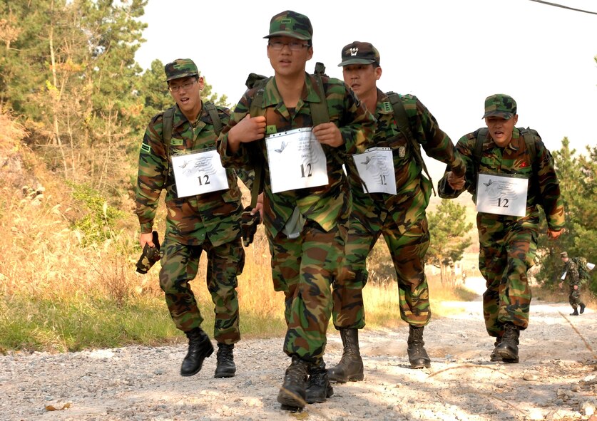 KUNSAN AIR BASE, South Korea  --  Republic of Korea Air Force members (left to right), Private First Class Kim Hyung Min, Private First Class Hyo Sung Kang, Captain In Sung Bae, and Private First Class Lee Jung Hun, navigate through a wooded portion of the course during the 1st Annual Veterans Day Memorial Ruck/Run here Nov. 17. Ten teams comprised of four members participated in a 10K march carrying 40 pound ruck sacks followed by a 1.5 mile run. Teams from the Republic of Korea Air Force joined U.S. teams from Kunsan and Osan Air Bases for the competition in an effort to build teamwork and camaraderie.  (U.S. Air Force photo/ Tech. Sgt. Quinton T. Burris)
