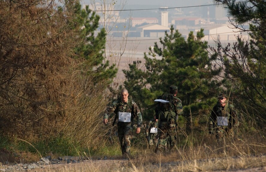 KUNSAN AIR BASE, South Korea--  Competitors in the 1st Annual Veterans Day Memorial Ruck/Run, navigate through a wooded portion of the course here Nov. 17.  Ten teams comprised of four members participated in a 10K march carrying 40 pound ruck sacks followed by a 1.5 mile run. Teams from the Republic of Korea Air Force joined U.S. teams from Kunsan and Osan Air Bases for the competition in an effort to build teamwork and camaraderie.  (U.S. Air Force Photo/Master Sgt. Jack Braden)
