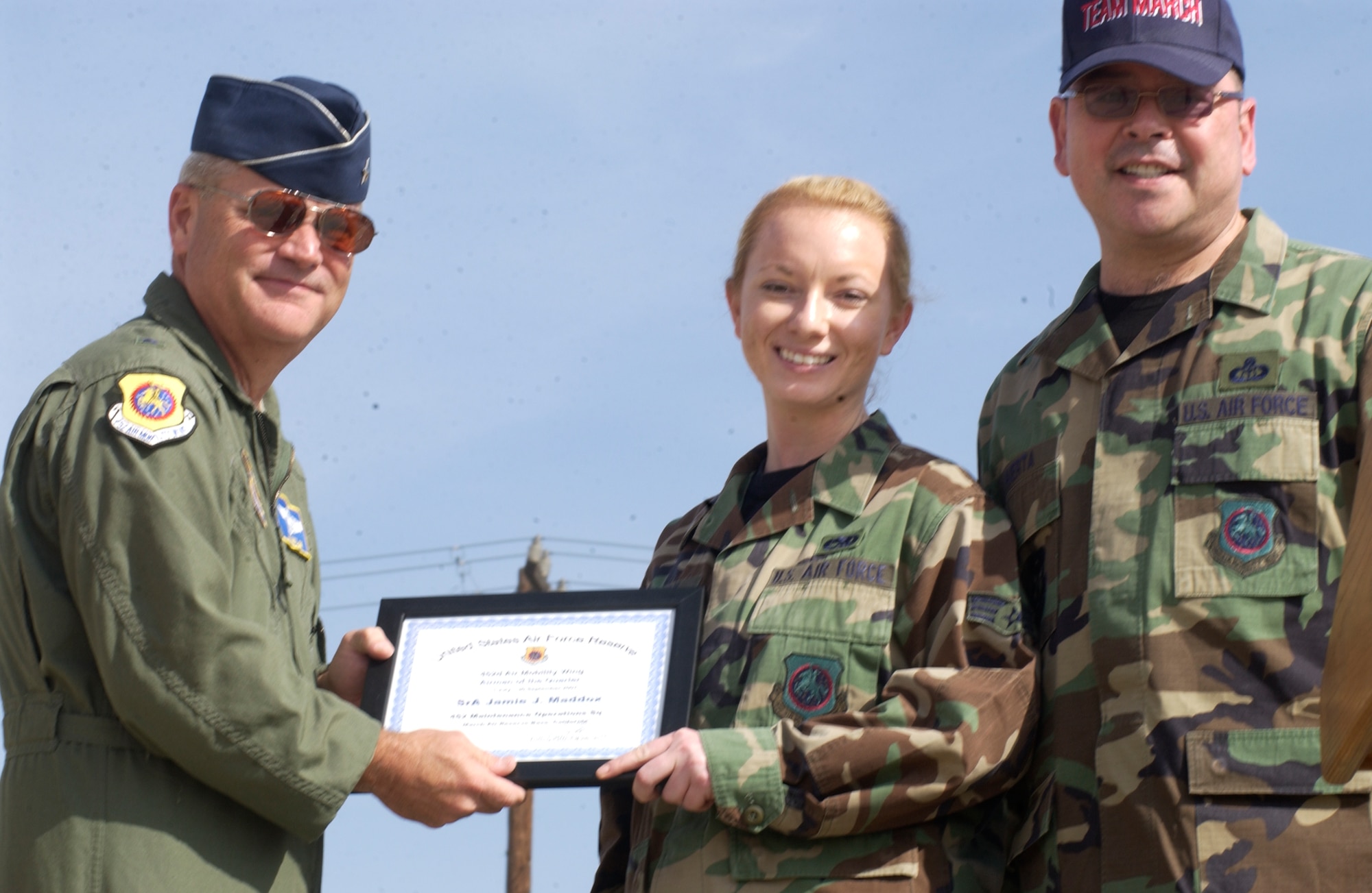 Senior Airman Jaime Maddox, center, is recognized as March Air Reserve Base's Airman of the quarter.  She is presented the award by Brig. Gen. James Melin, left, commander of the 452nd AMW, and Chief Master Sgt. Agustin Huerta, command chief. The 452nd Air Mobility Wing names its award winners for the fourth quarter of 2007.  The Airman of the quarter was Senior Airman Jaime Maddox from the 452nd Maintenance Operations Squadron.  The NCO of the quarter was Technical Sgt. Diana Perez, 729th Airlift Squadron.  The senior NCO of the quarter was Master Sgt. Javier Padilla from the 452nd Aeromedical Staging Squadron.  The officer of the quarter was Capt. Robert Simmons from the 452nd Aerospace Medicine Squadron.  The civilian of the quarter from GS-1 through GS-6 was Charrice Netters from the 452nd Mission Support Squadron.  The WG category winner was Jason Knapp from 452 Aircraft Maintenance Squadron.  The WS category winner was Berton Perkins from 452 Aircraft Maintenance Squadron.  (U.S. Air Force photo by Staff Sgt. Joe Davidson/ 452 AMW)